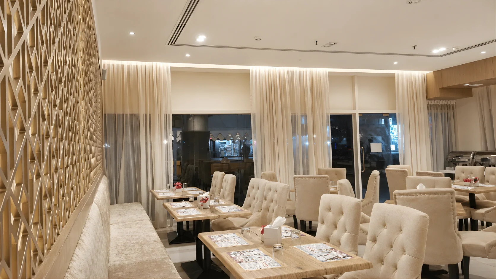 Restaurant seating design in Dubai with custom banquette seating, textured wall panels, and warm ambient lighting