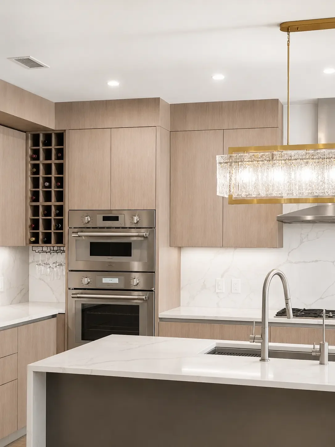 Transitional kitchen detail with double ovens, quartz island, and light wood cabinetry in Woodland Park NJ.