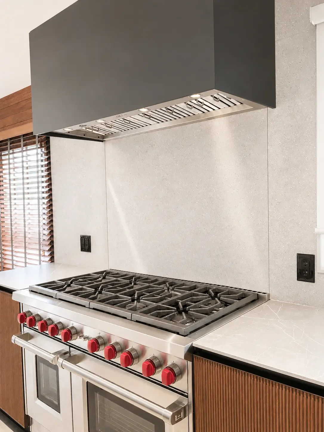 Ribbed wood kitchen cabinetry with quartz countertop and sub zero range and appliances in Franklin Lakes NJ.