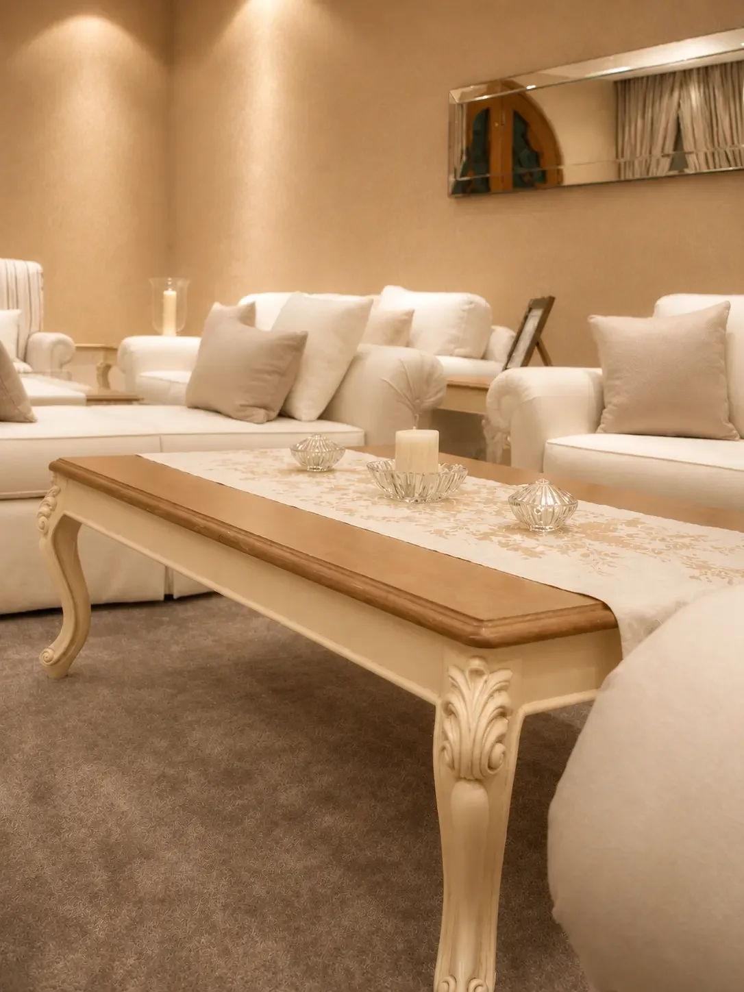 Semi-classical living room detail featuring custom upholstered seating and carved coffee table with neutral styling.