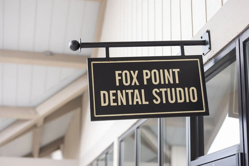 Sign for Fox Point Dental Studio hanging outside the building.