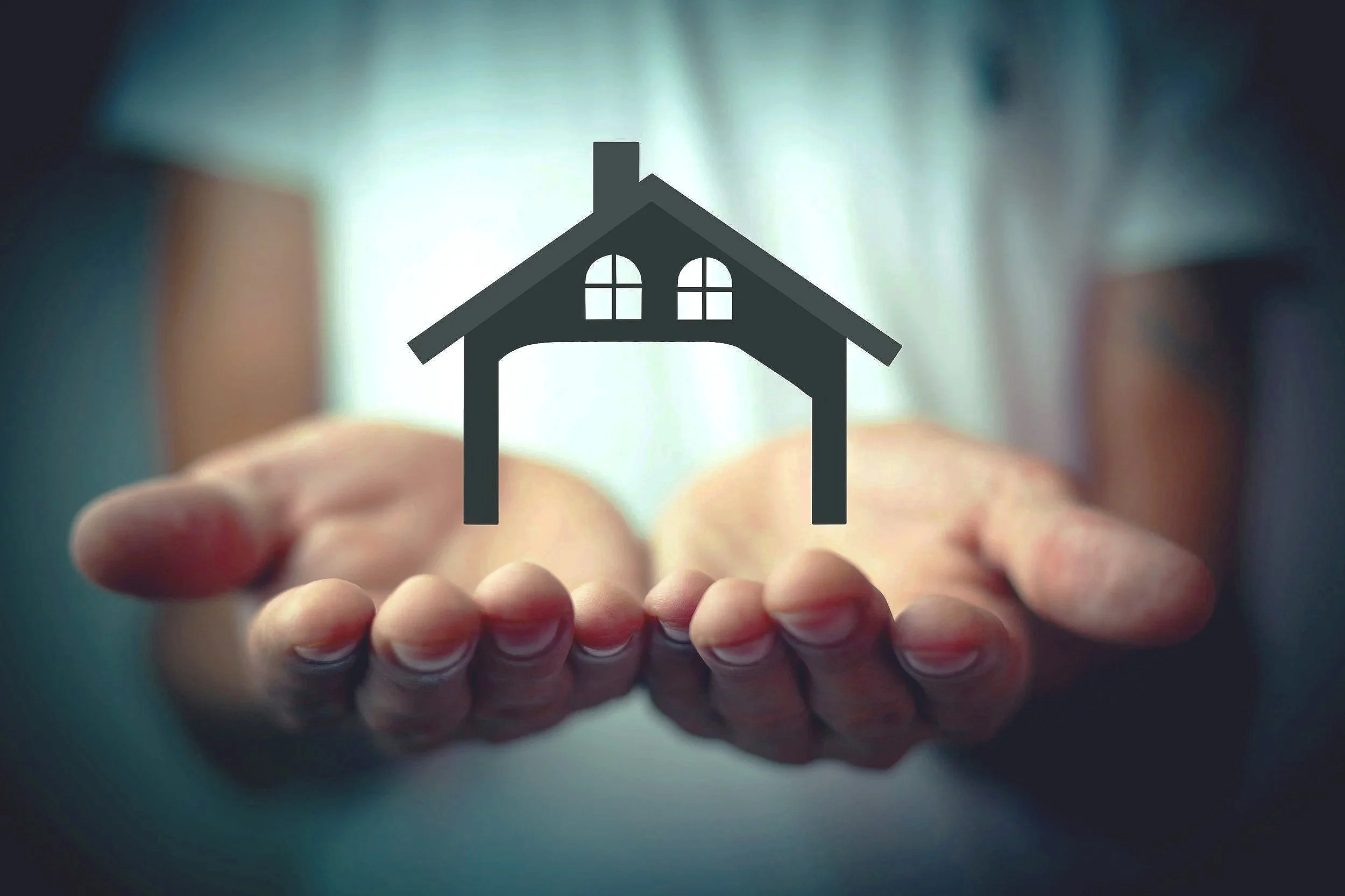 A person holding out their hand with a simple black house icon with a chimney and arched windows overlayed.