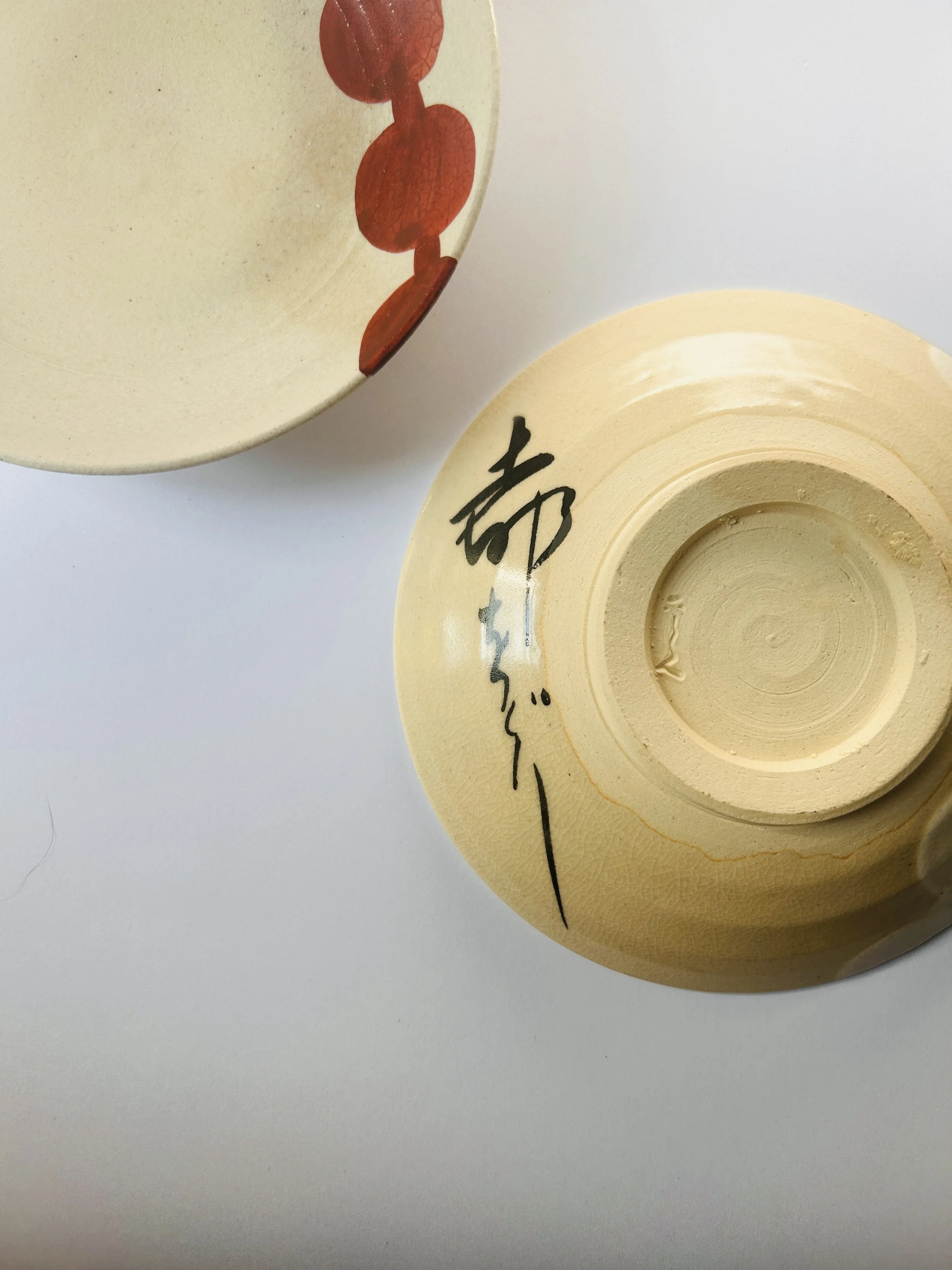 Set of vintage Japanese Miyako Odori ceramic plates with hand painted circular patterns in earthy tones