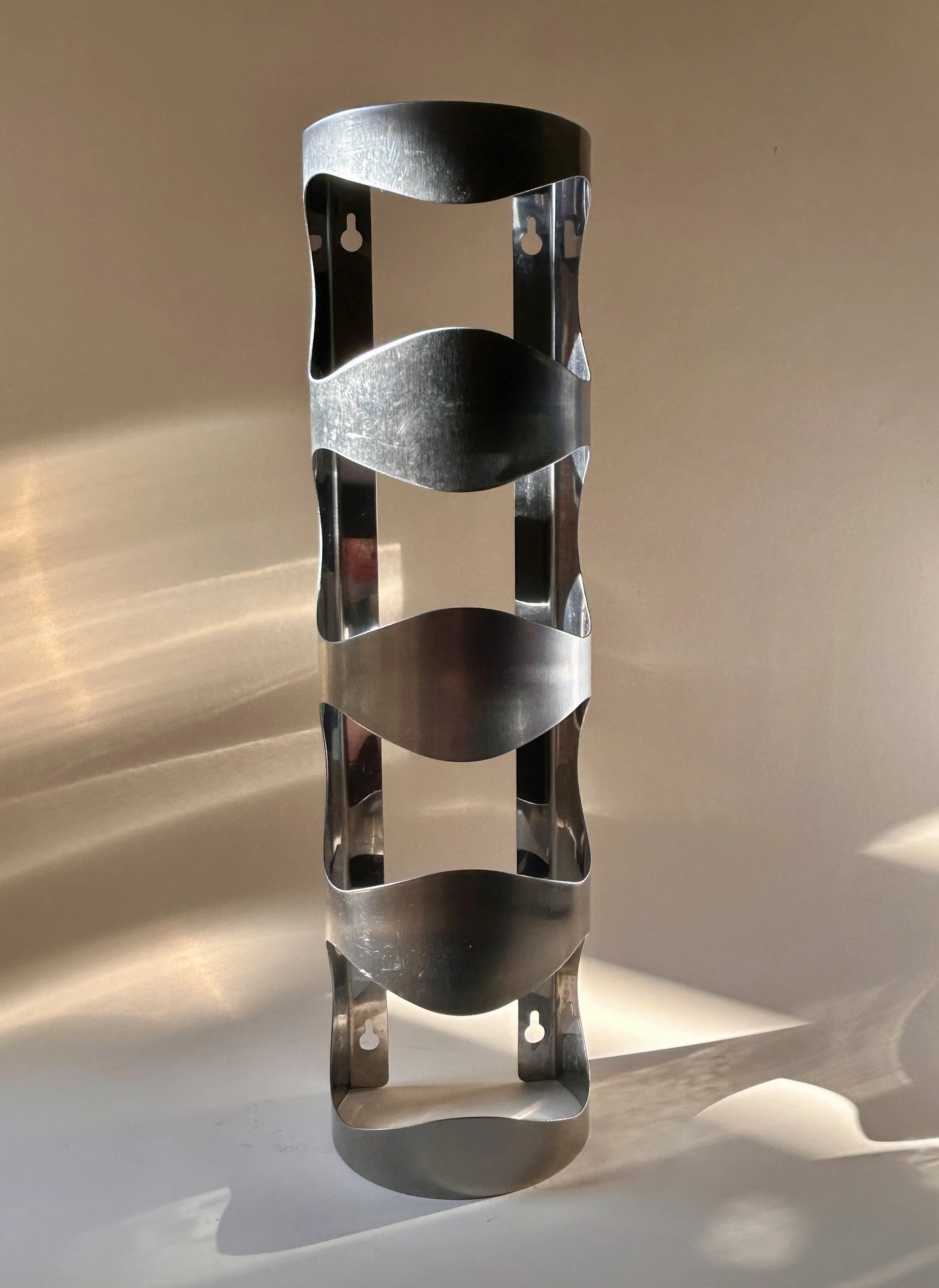 Discontinued IKEA VURM stainless steel wall-mounted wine rack by Karl Malmvall with four curved bottle holders.
