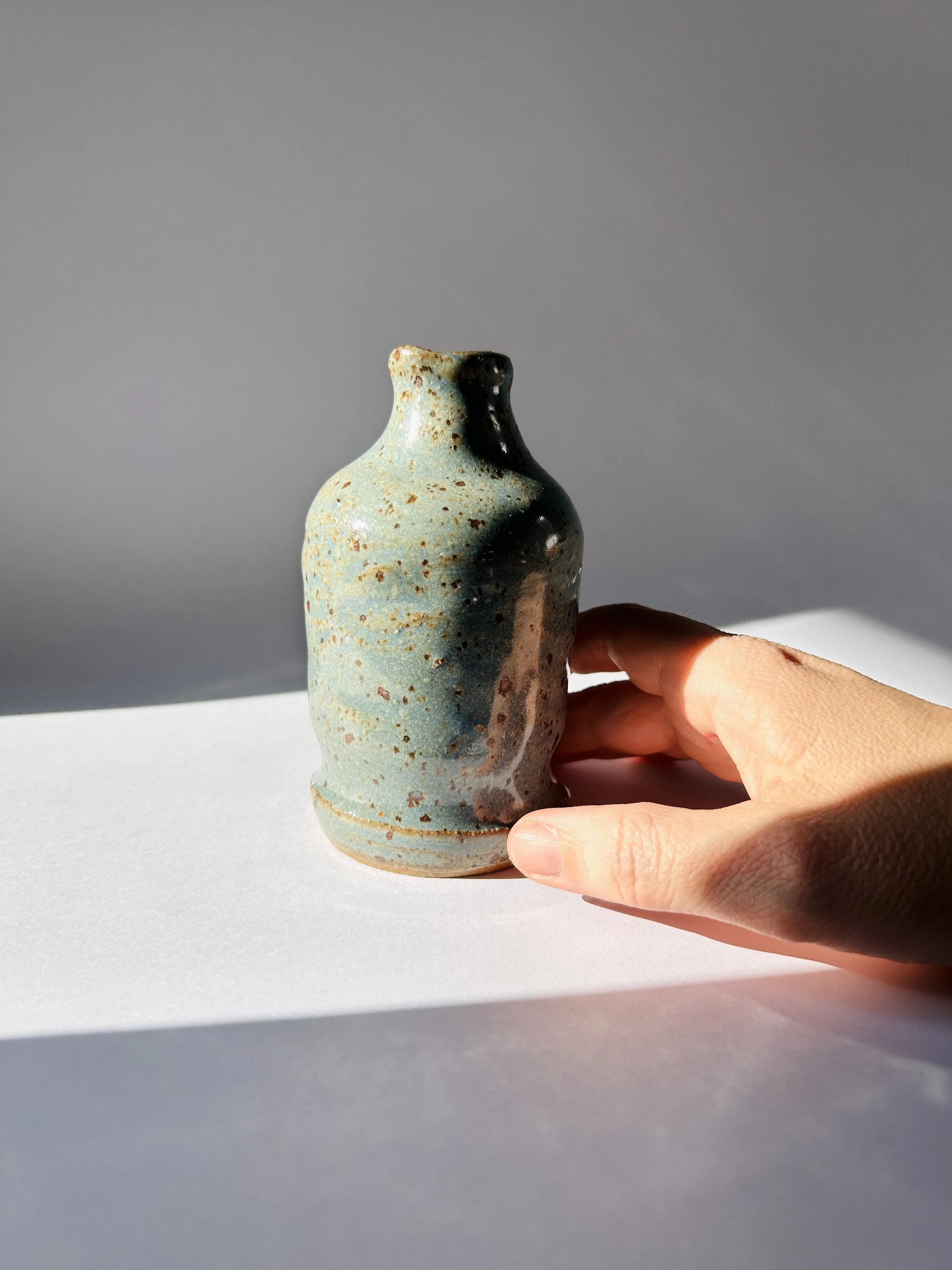 Handmade robin’s egg blue ceramic bud vase with speckled glaze, small studio pottery vessel with greenery