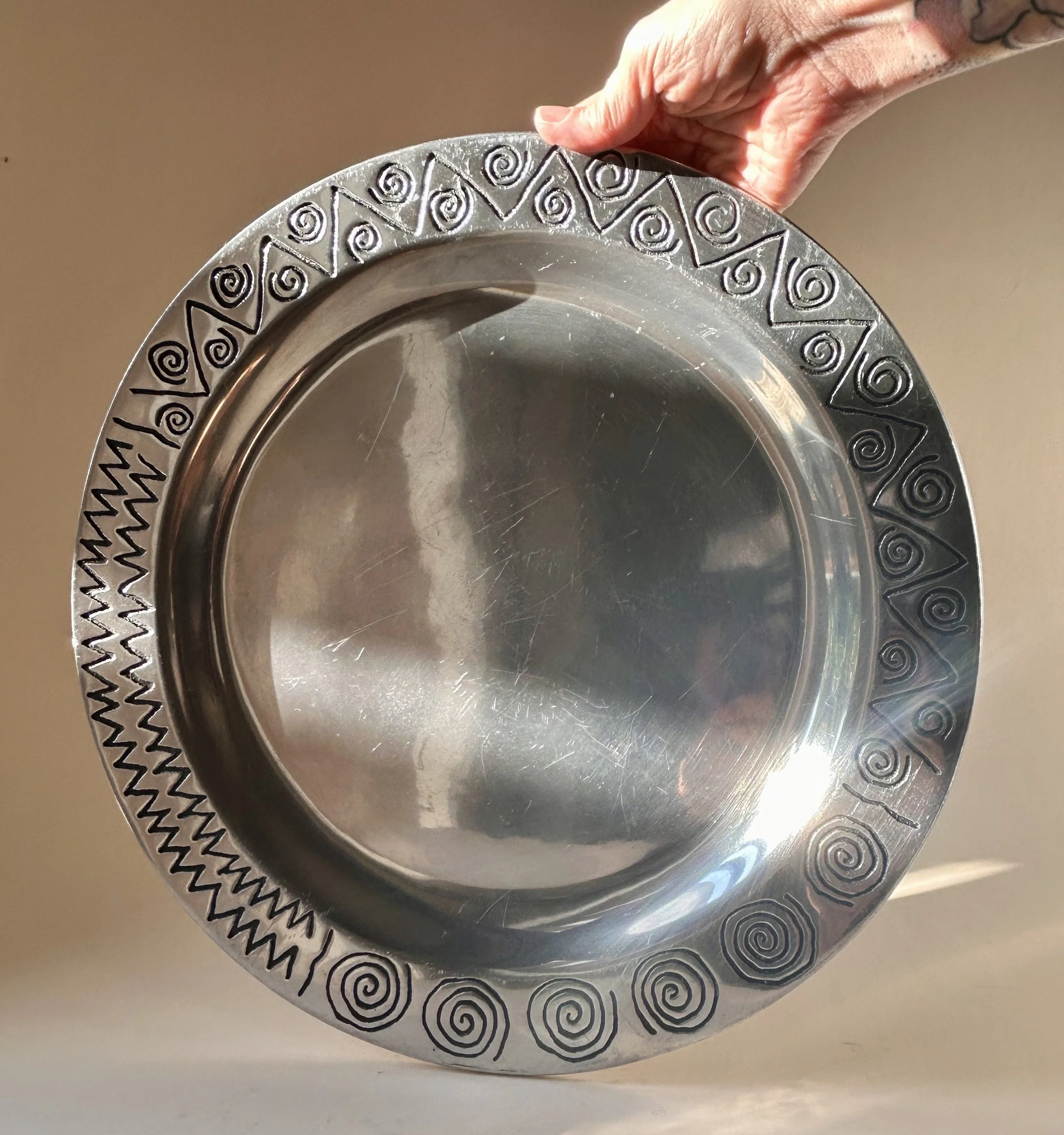 Vintage Wilton Armetale Reggae round metal platter with engraved spiral, zigzag, and geometric border.