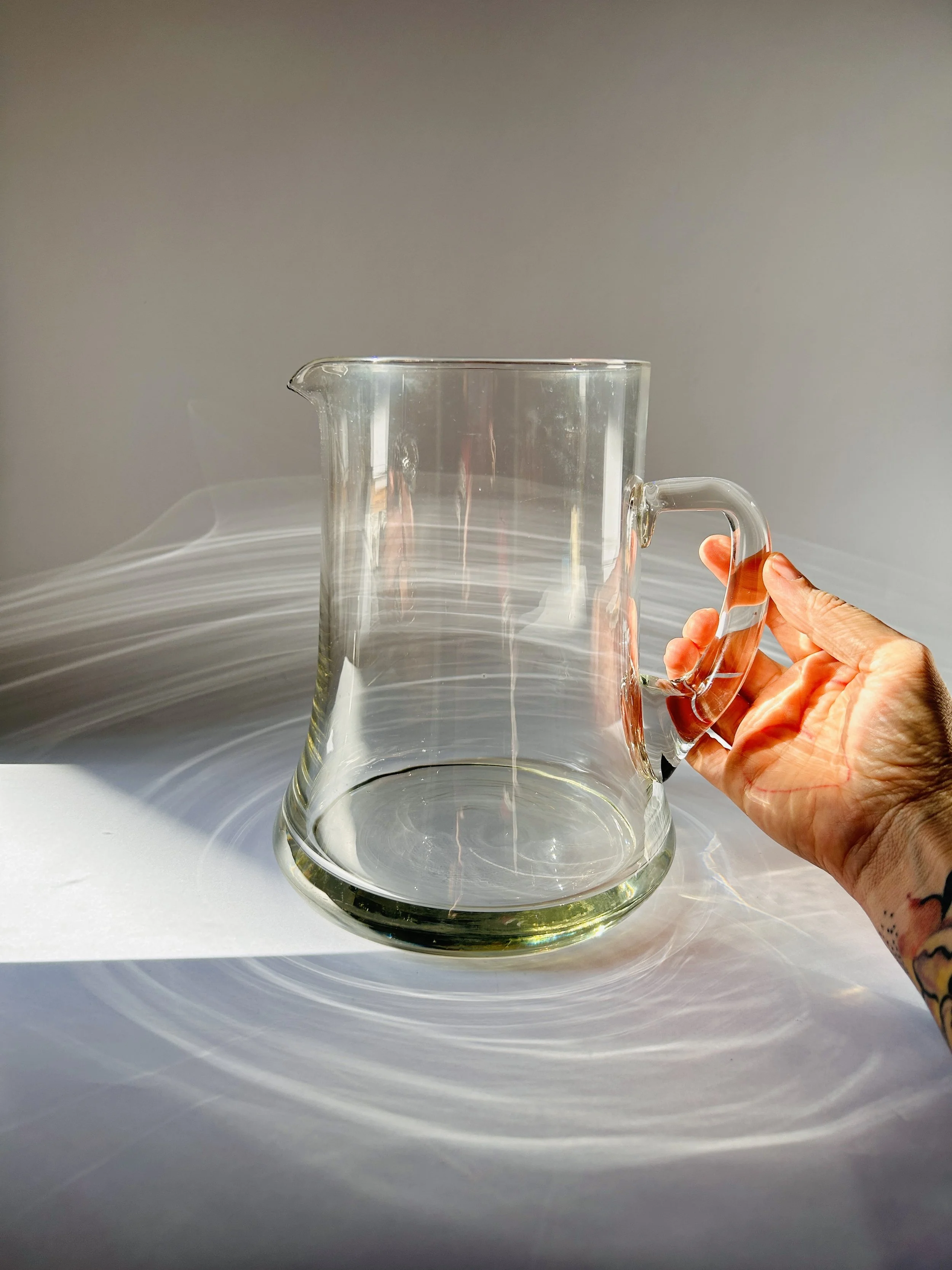 clear glass pitcher with heavy base and handle, minimalist modern drink carafe