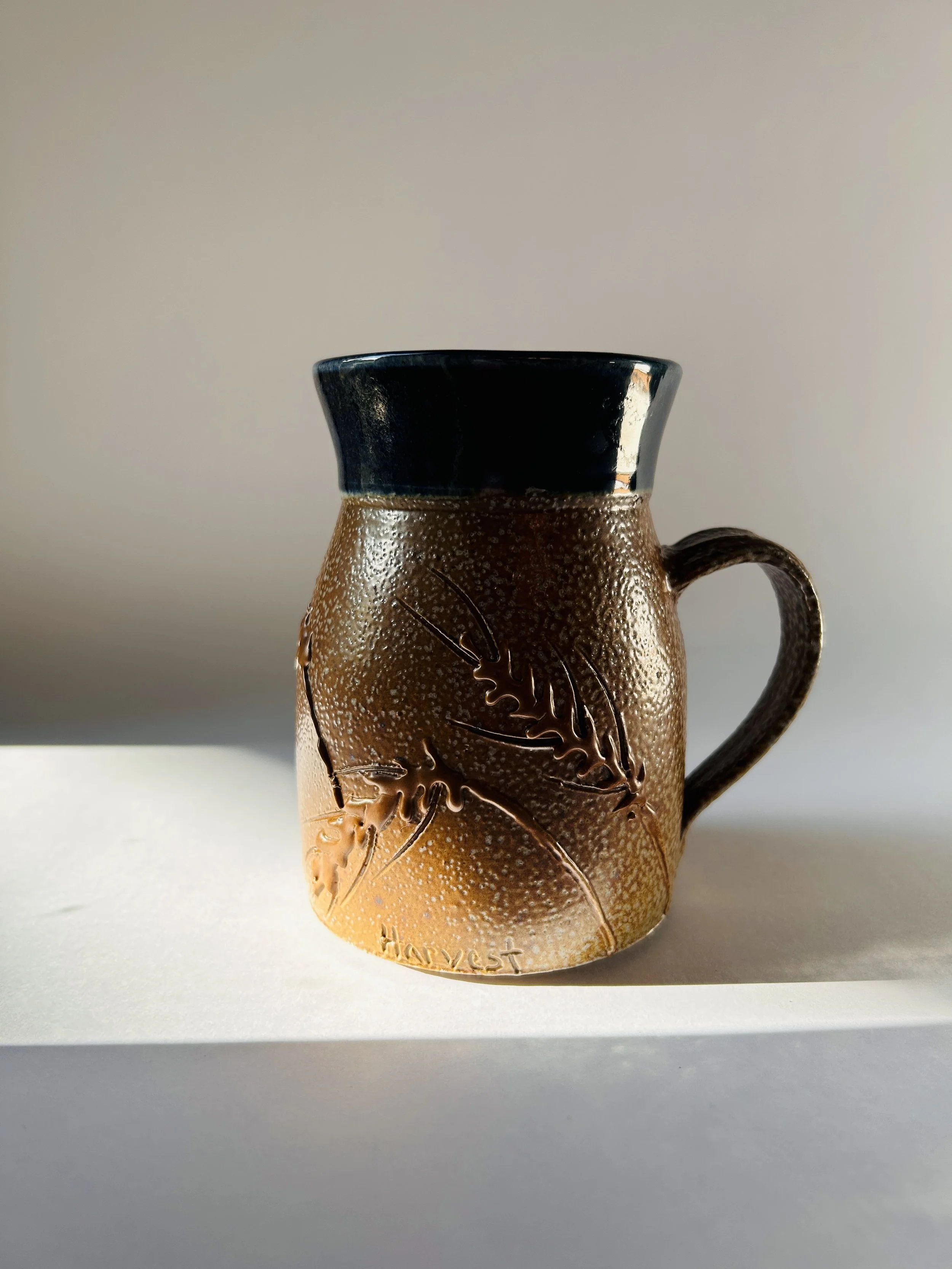 handmade ceramic mug with embossed wheat design and brown to blue glaze