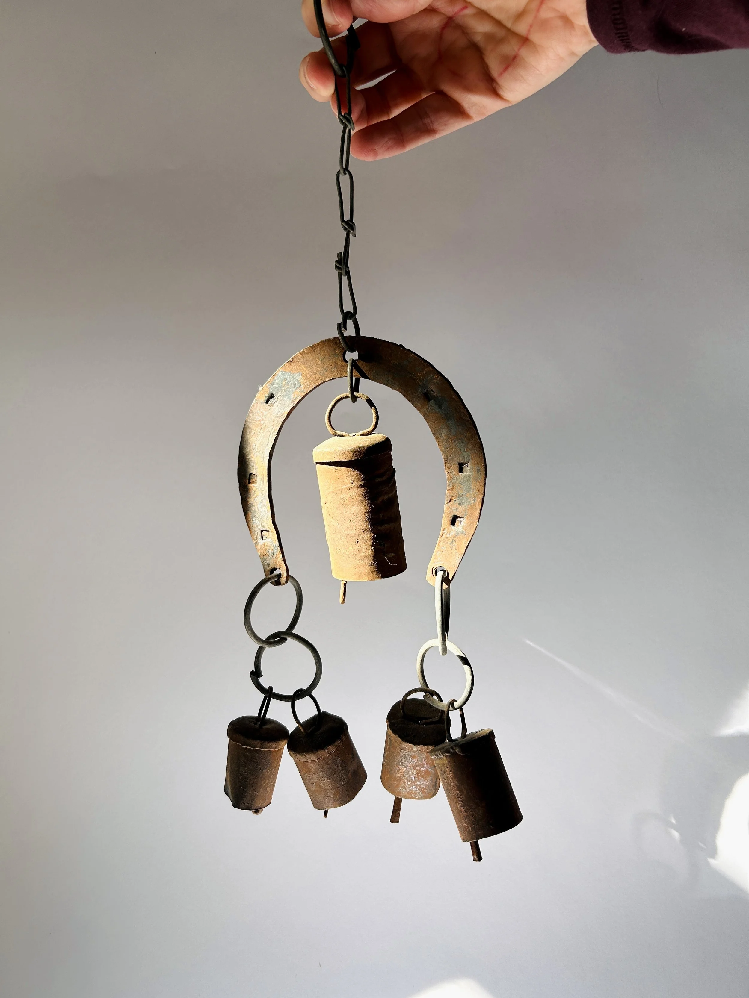 rustic metal wind chime with horseshoe frame and hanging bells