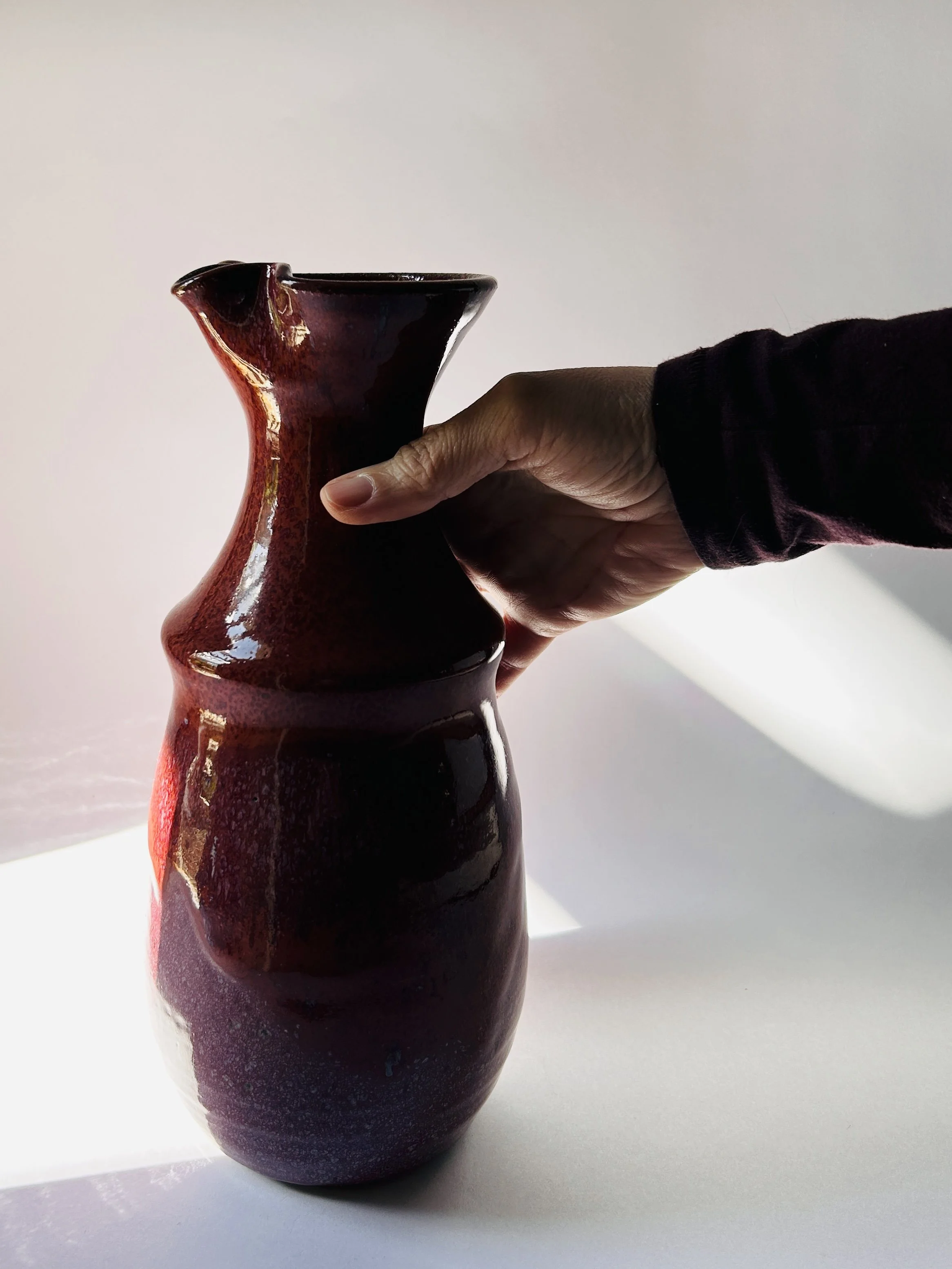 red and purple studio pottery decanter with ribbon mouth spout and textured glaze