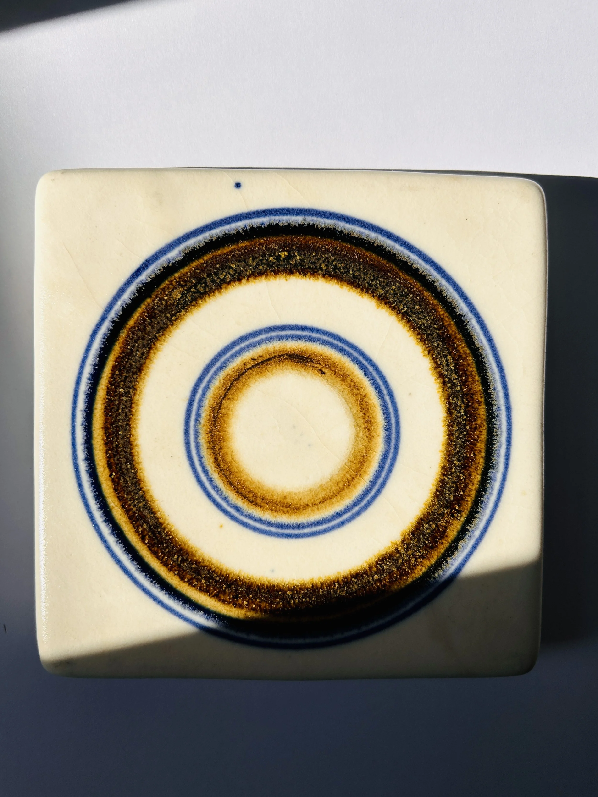 Vintage Arabia Finland Wellamo ceramic trivet with concentric circle design in blue and ochre tones