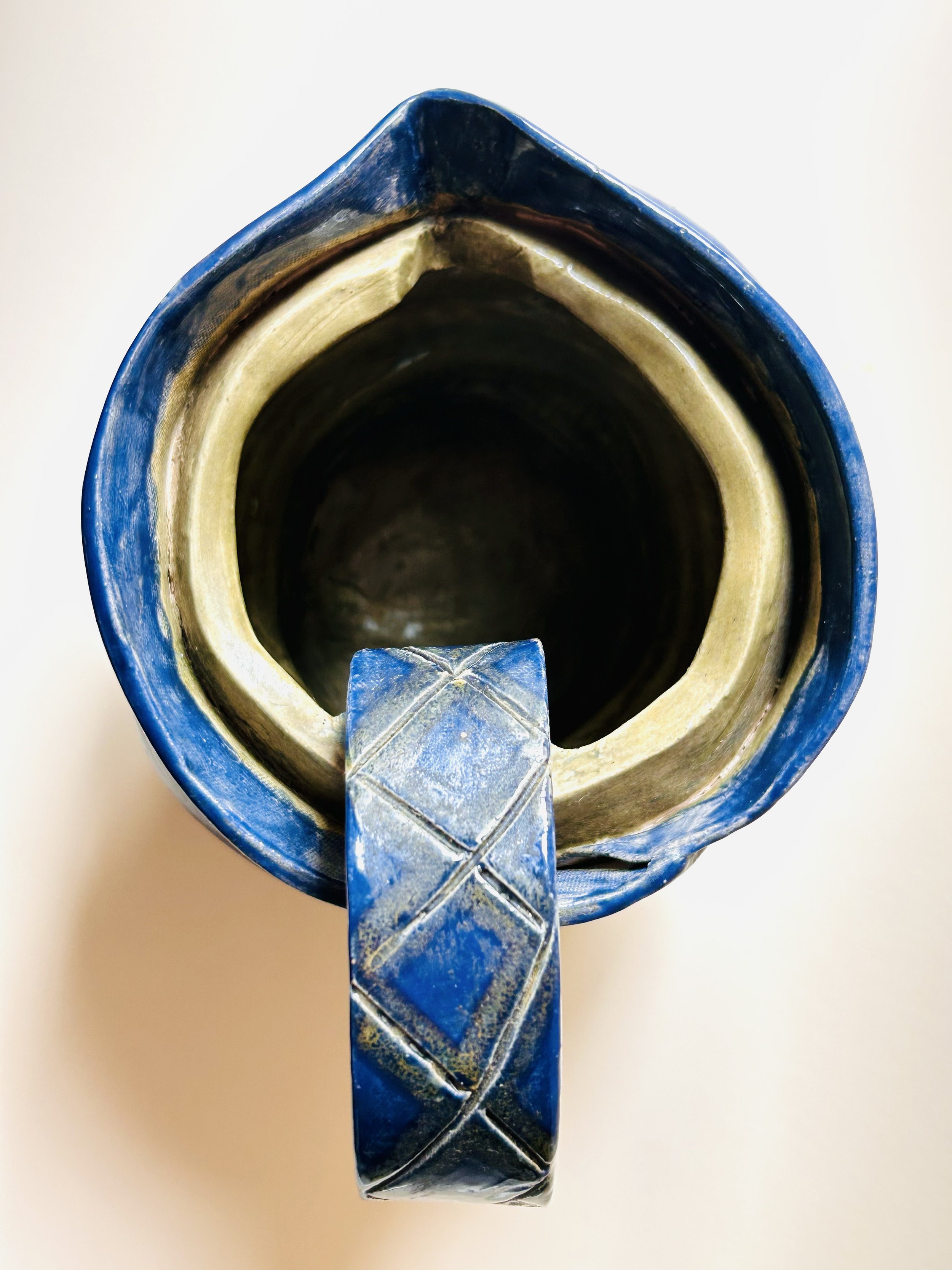 hand built dark blue studio pottery pitcher with sculptural handle