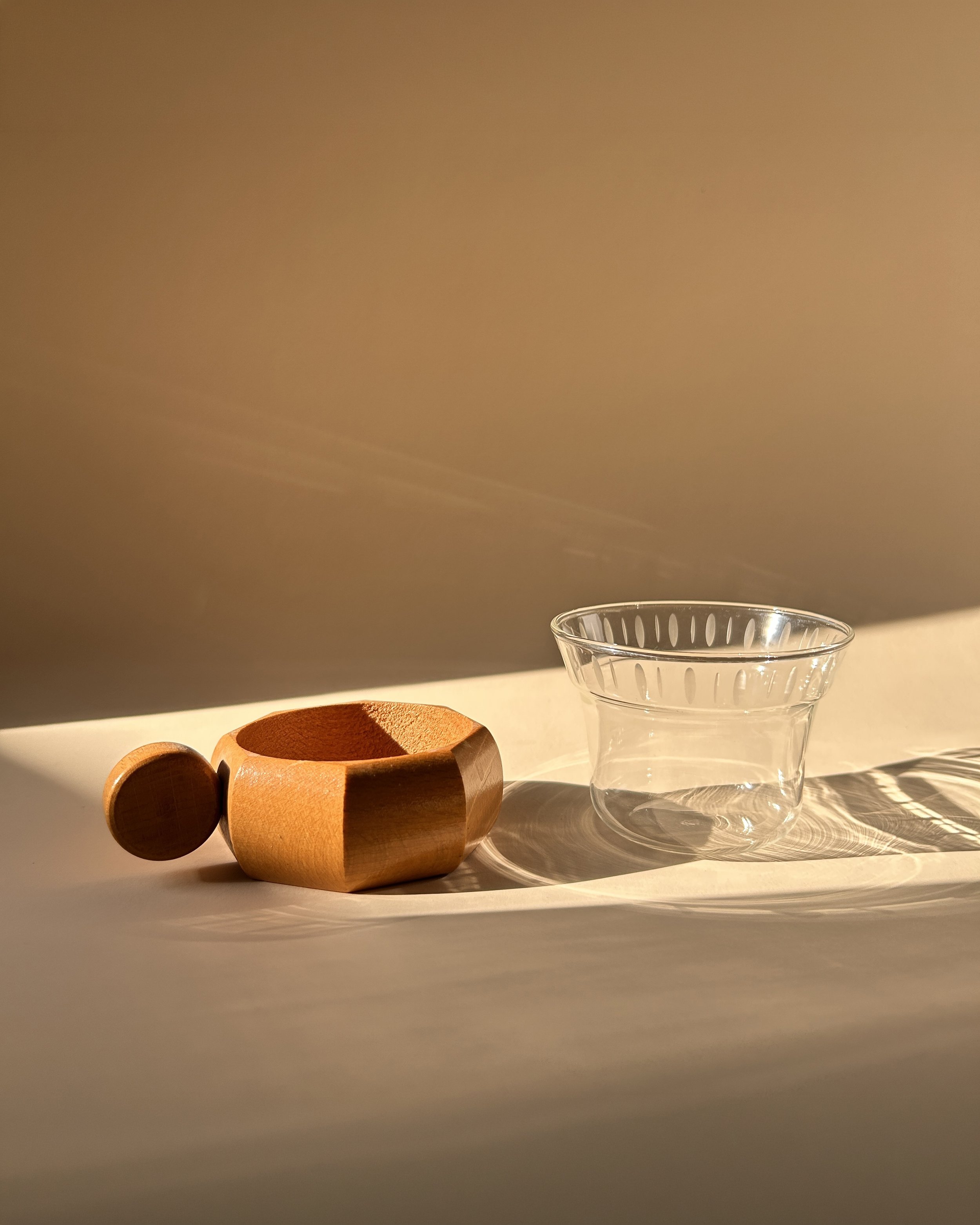 Set of four vintage German clear glass tea cups with frosted oval decoration, faceted wooden holders and round wood handles.