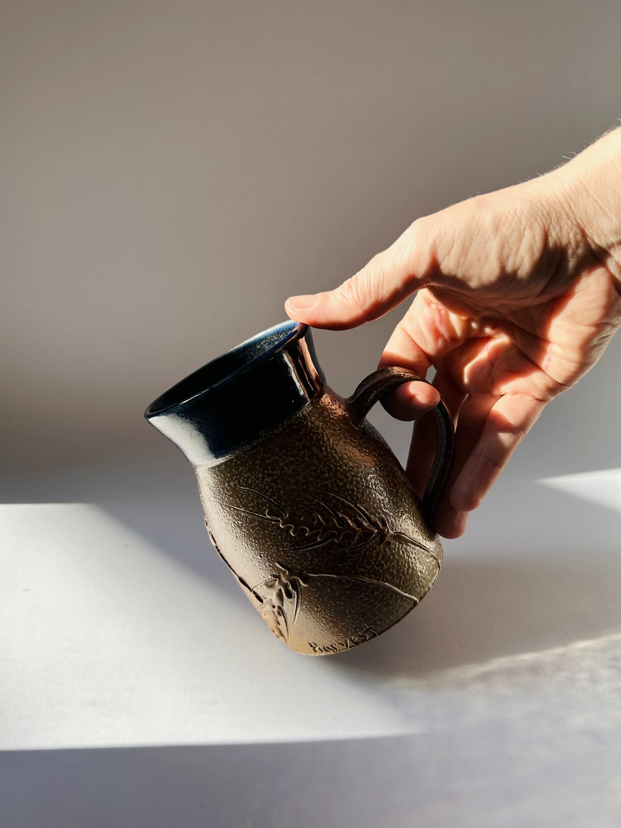 handmade ceramic mug with embossed wheat design and brown to blue glaze