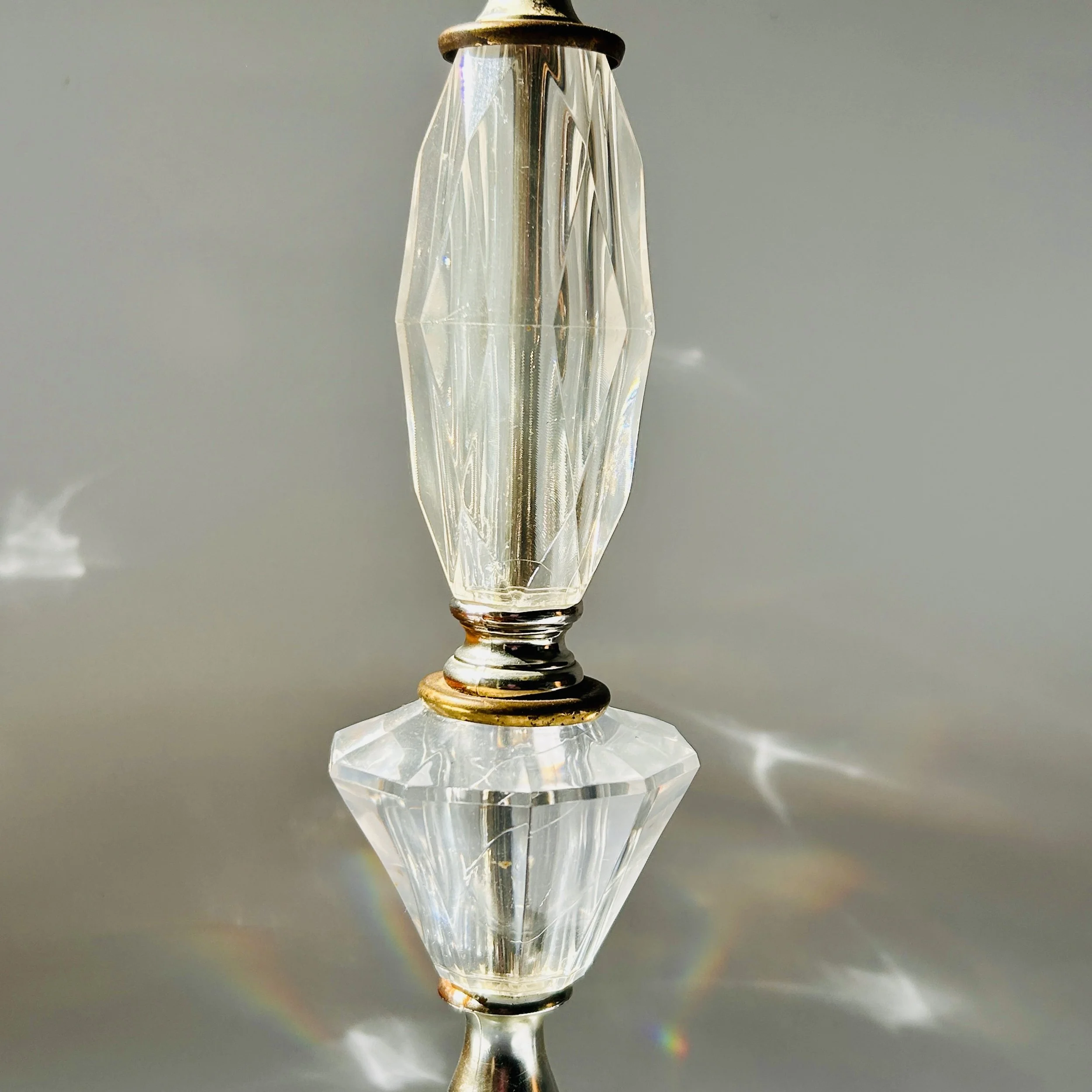 Vintage table lamp with faceted clear crystal-look elements, silver-tone metal accents, pale marble square base, and exposed red bulb.