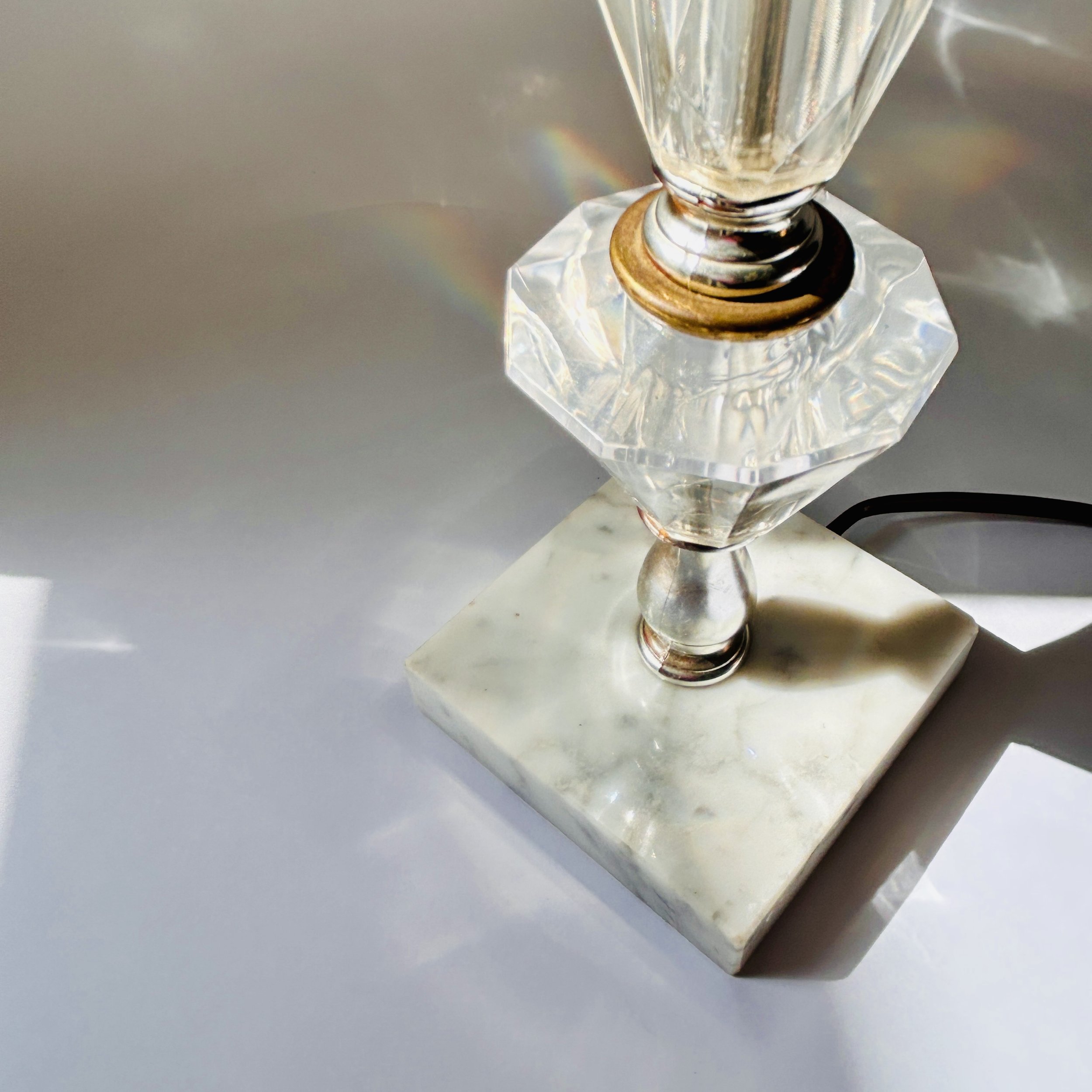 Vintage table lamp with faceted clear crystal-look elements, silver-tone metal accents, pale marble square base, and exposed red bulb.