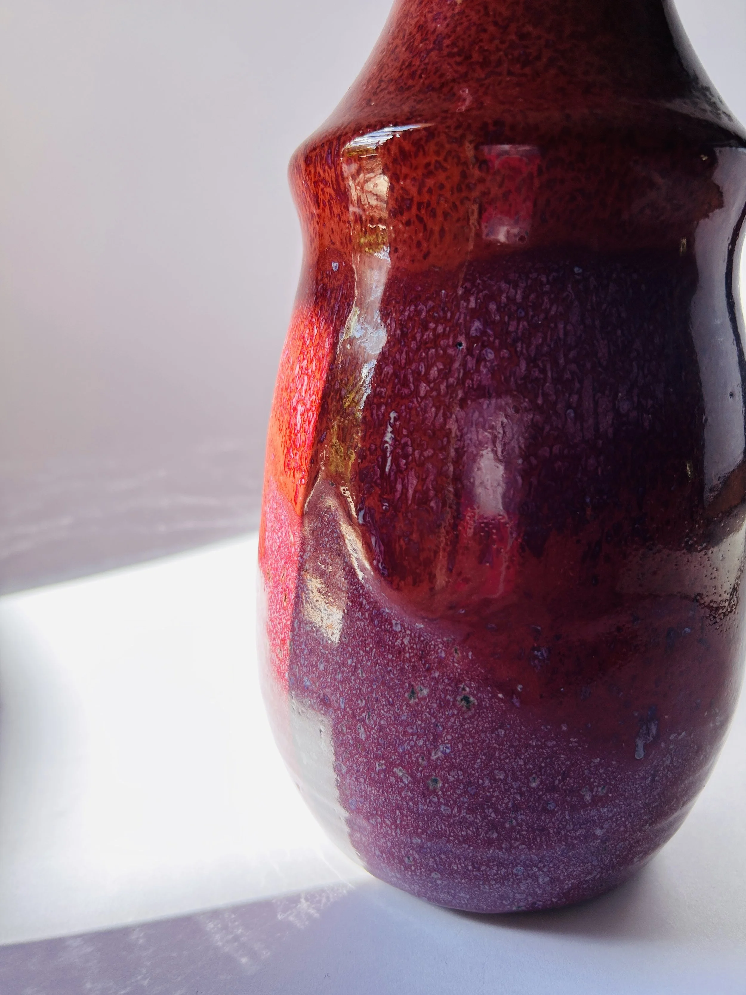 red and purple studio pottery decanter with ribbon mouth spout and textured glaze