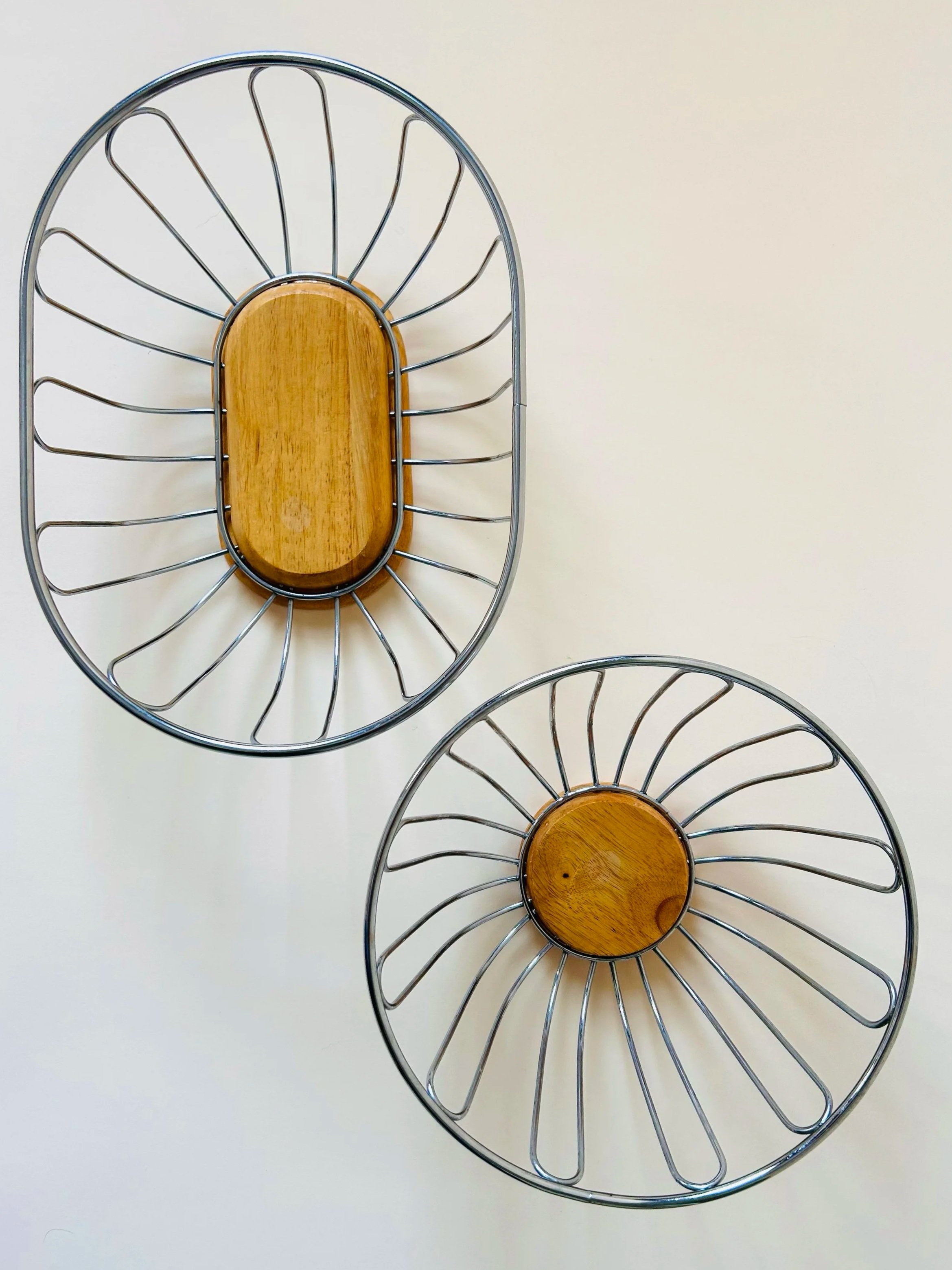 Modern stainless steel wire fruit basket with wooden base, minimalist kitchen storage bowl in natural light
