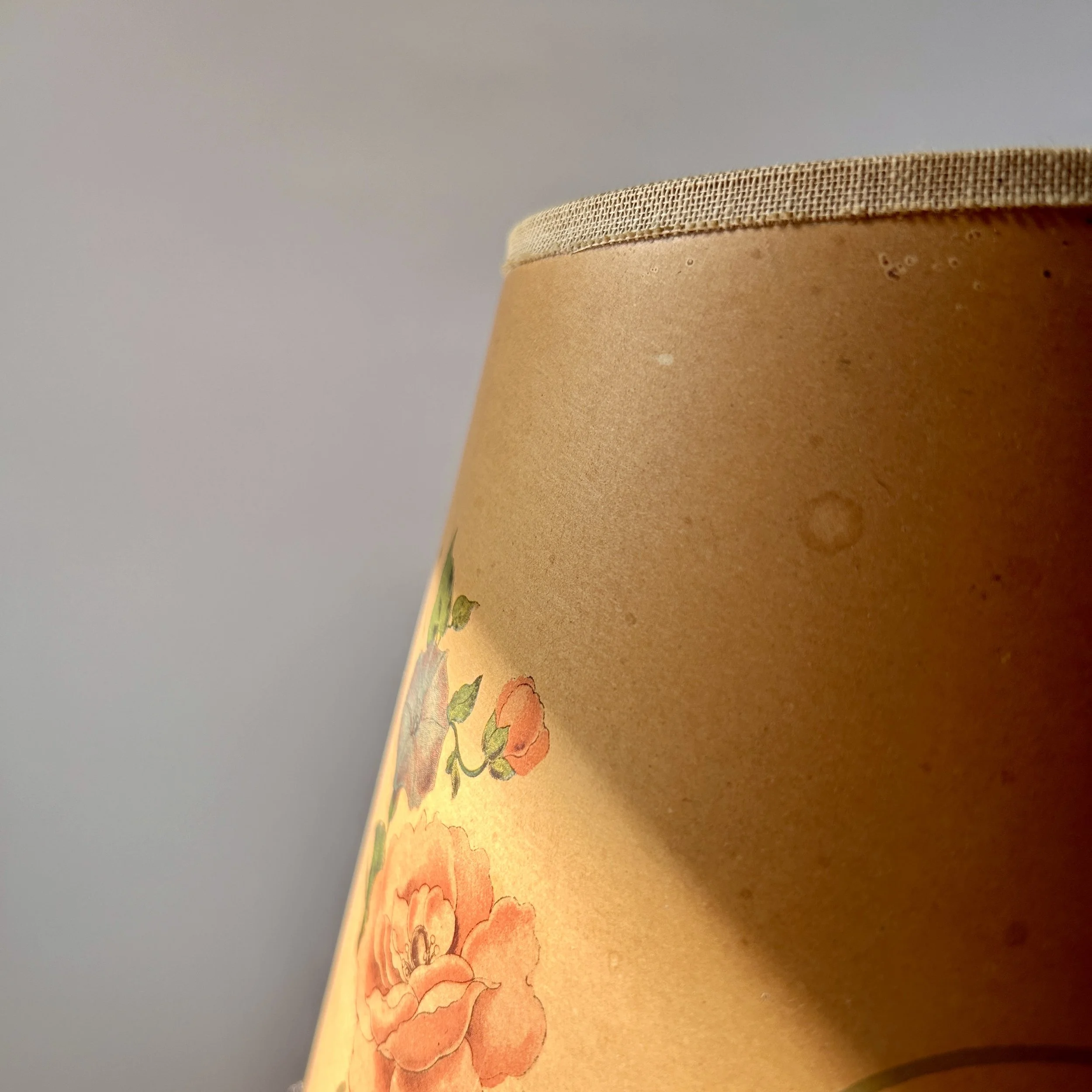 Vintage amber Bakelite table lamp with stepped geometric base, slender column, and warm brown floral lampshade.