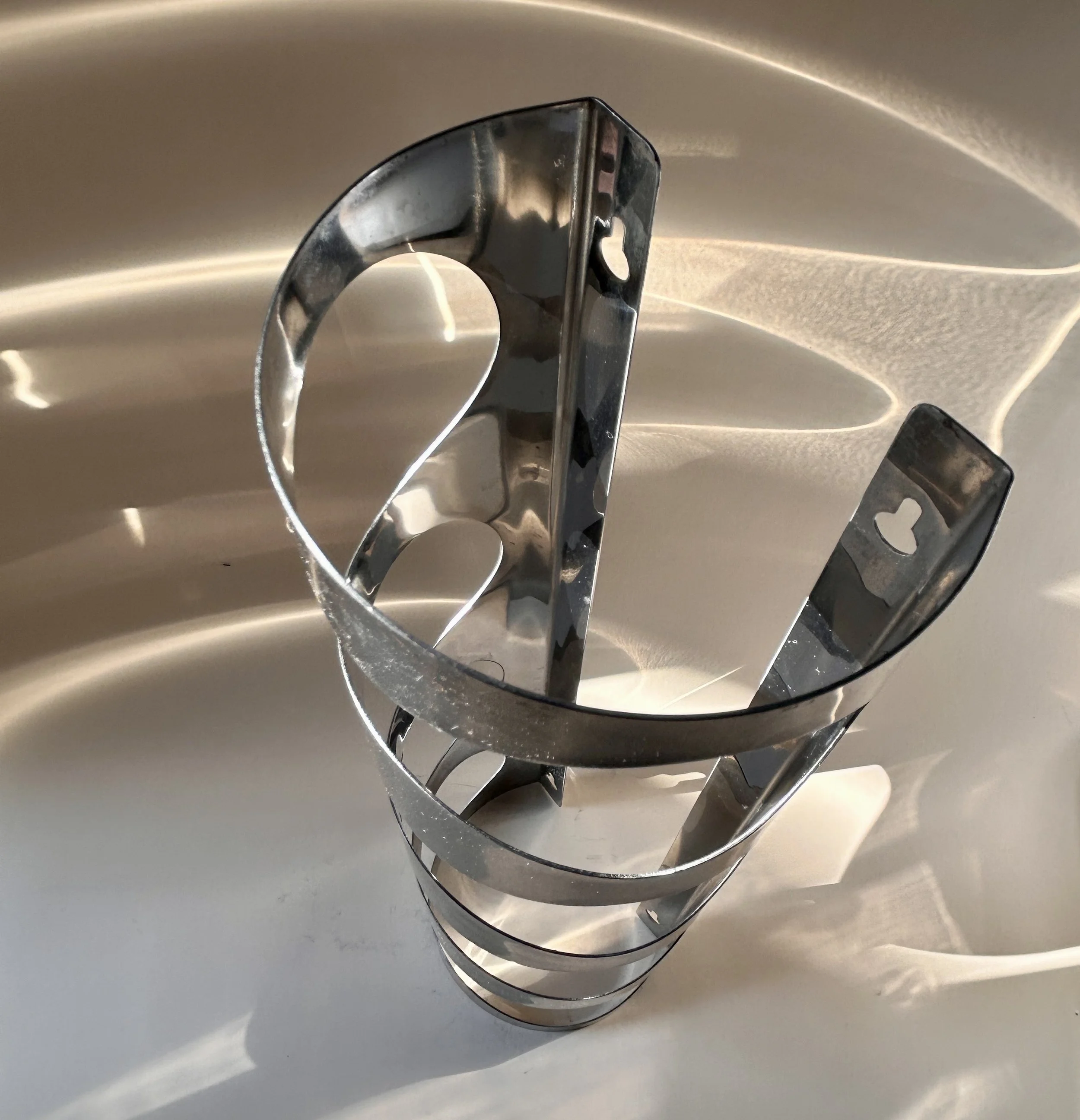 Discontinued IKEA VURM stainless steel wall-mounted wine rack by Karl Malmvall with four curved bottle holders.