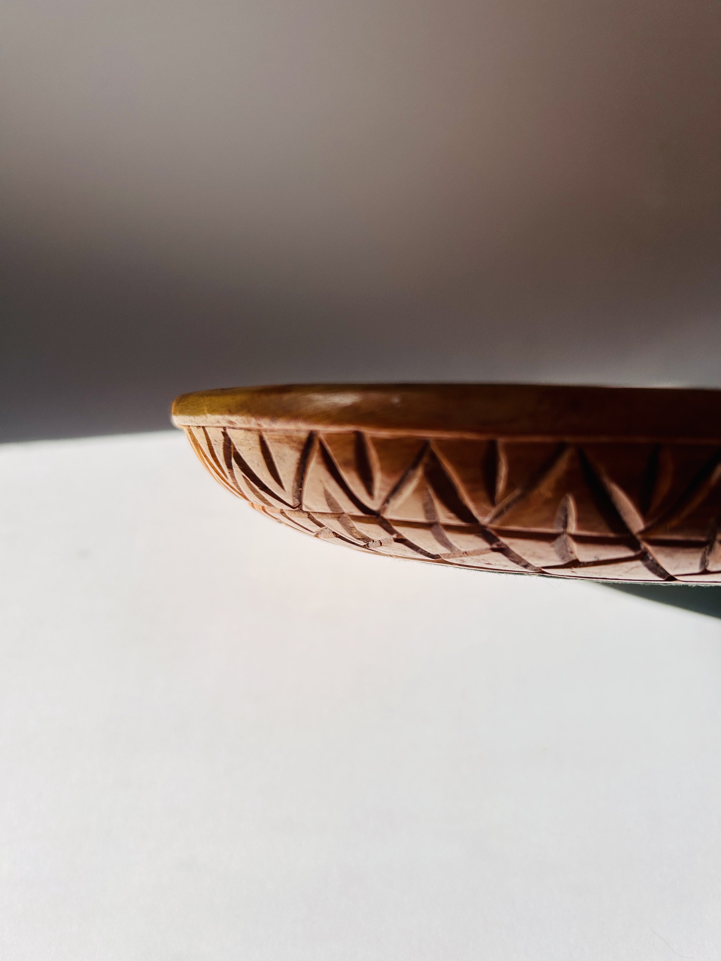 Primitive hand-carved wooden tray with organic shape and warm patina, rustic serving board