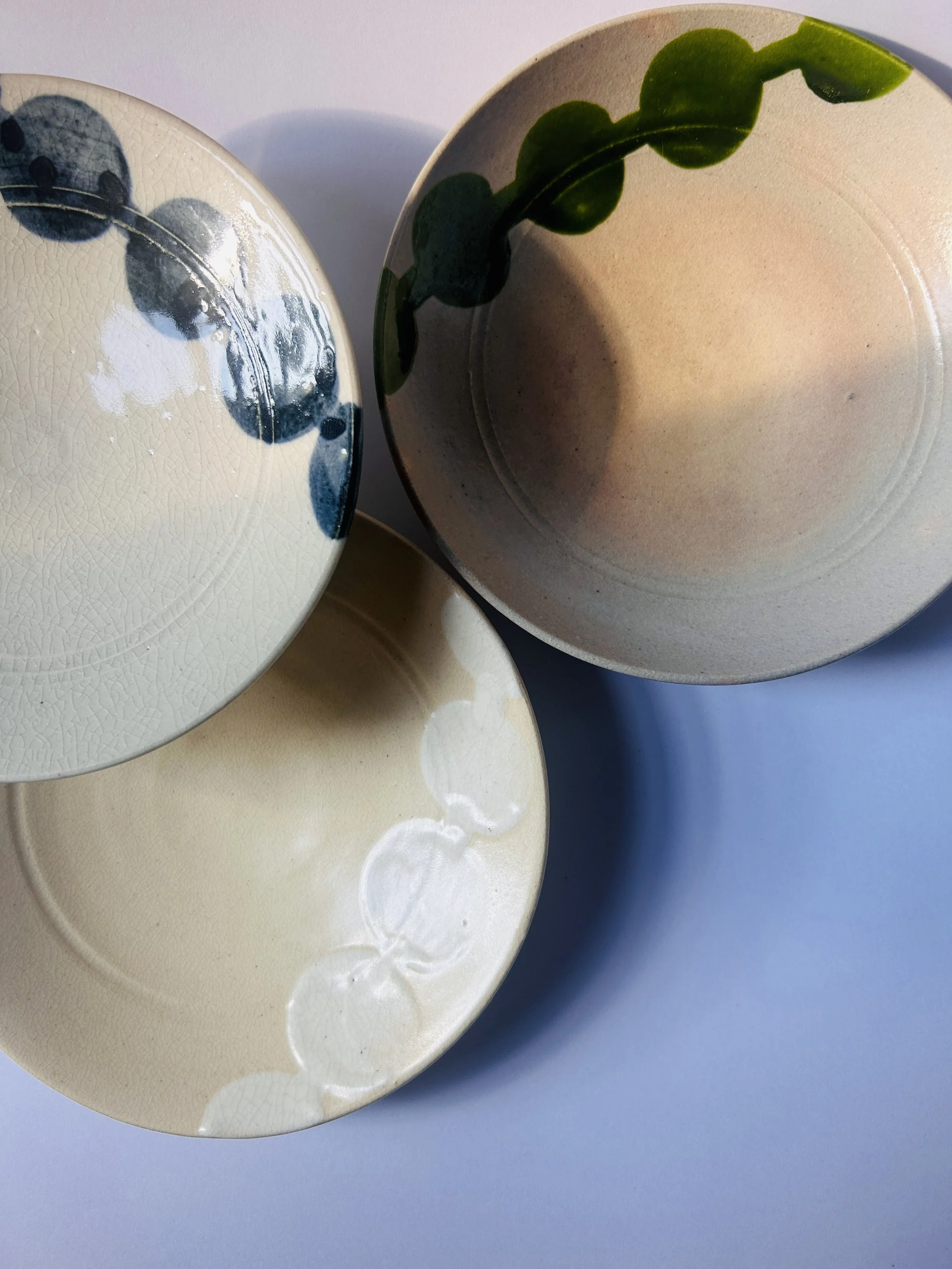 Set of vintage Japanese Miyako Odori ceramic plates with hand painted circular patterns in earthy tones