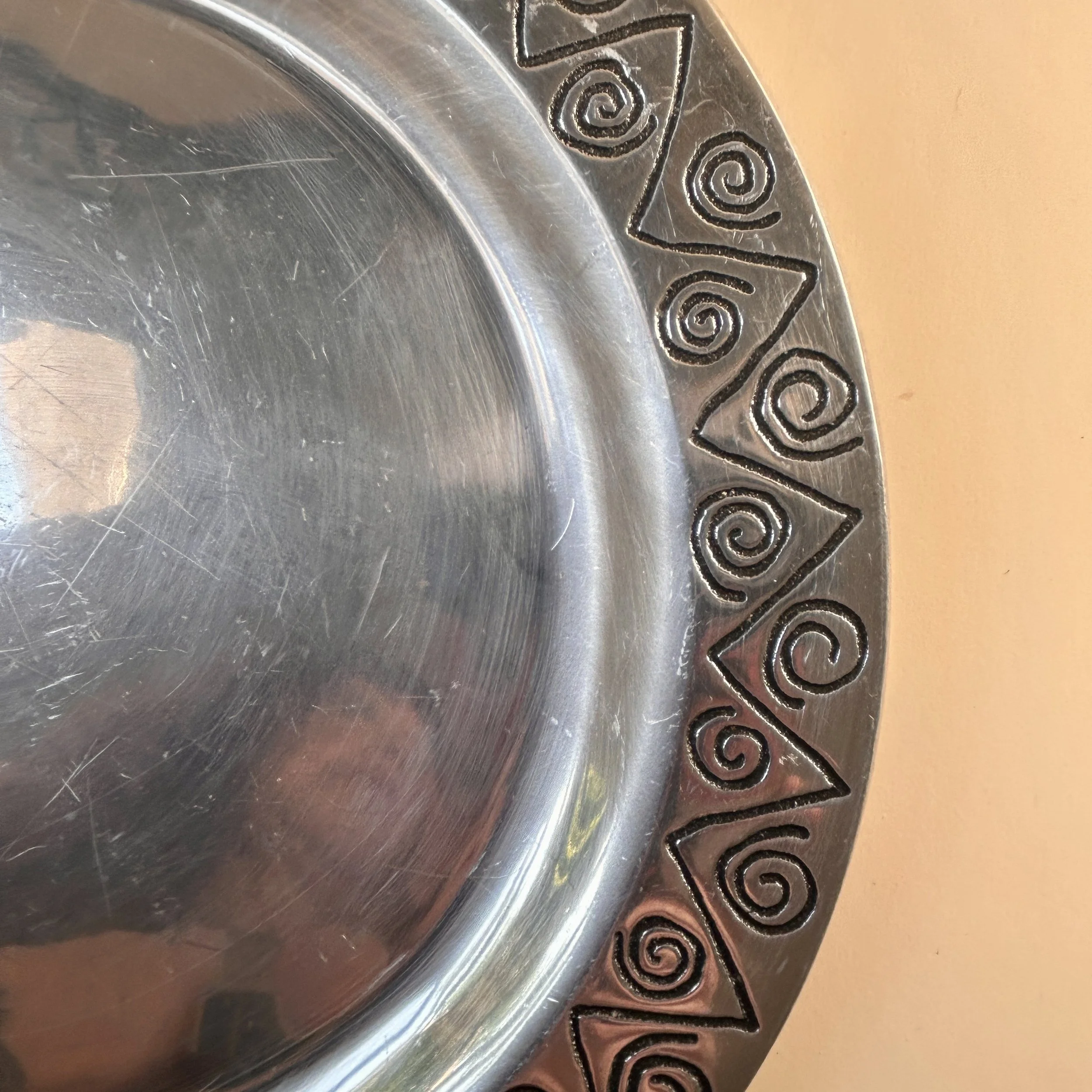 Vintage Wilton Armetale Reggae round metal platter with engraved spiral, zigzag, and geometric border.