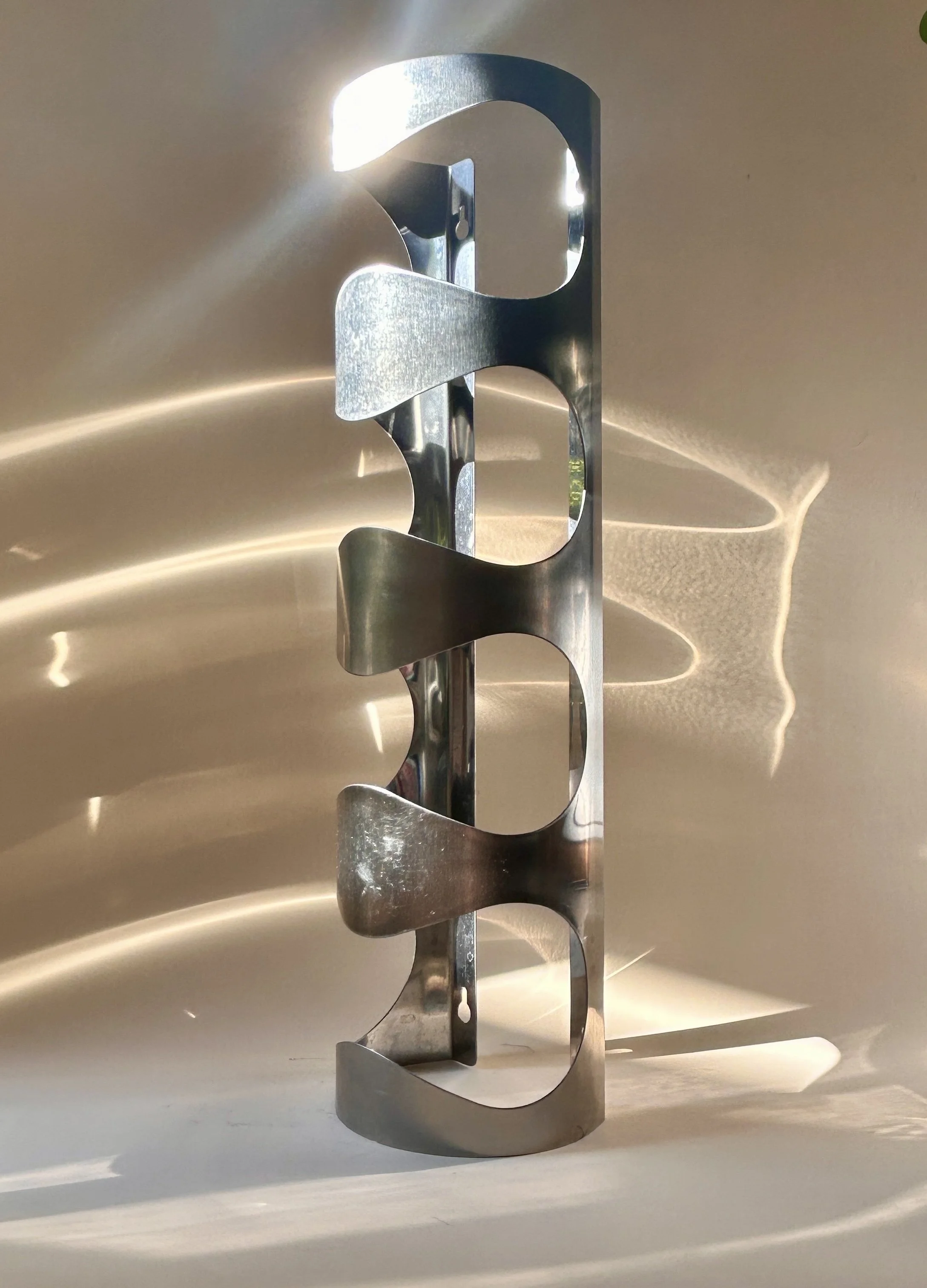 Discontinued IKEA VURM stainless steel wall-mounted wine rack by Karl Malmvall with four curved bottle holders.
