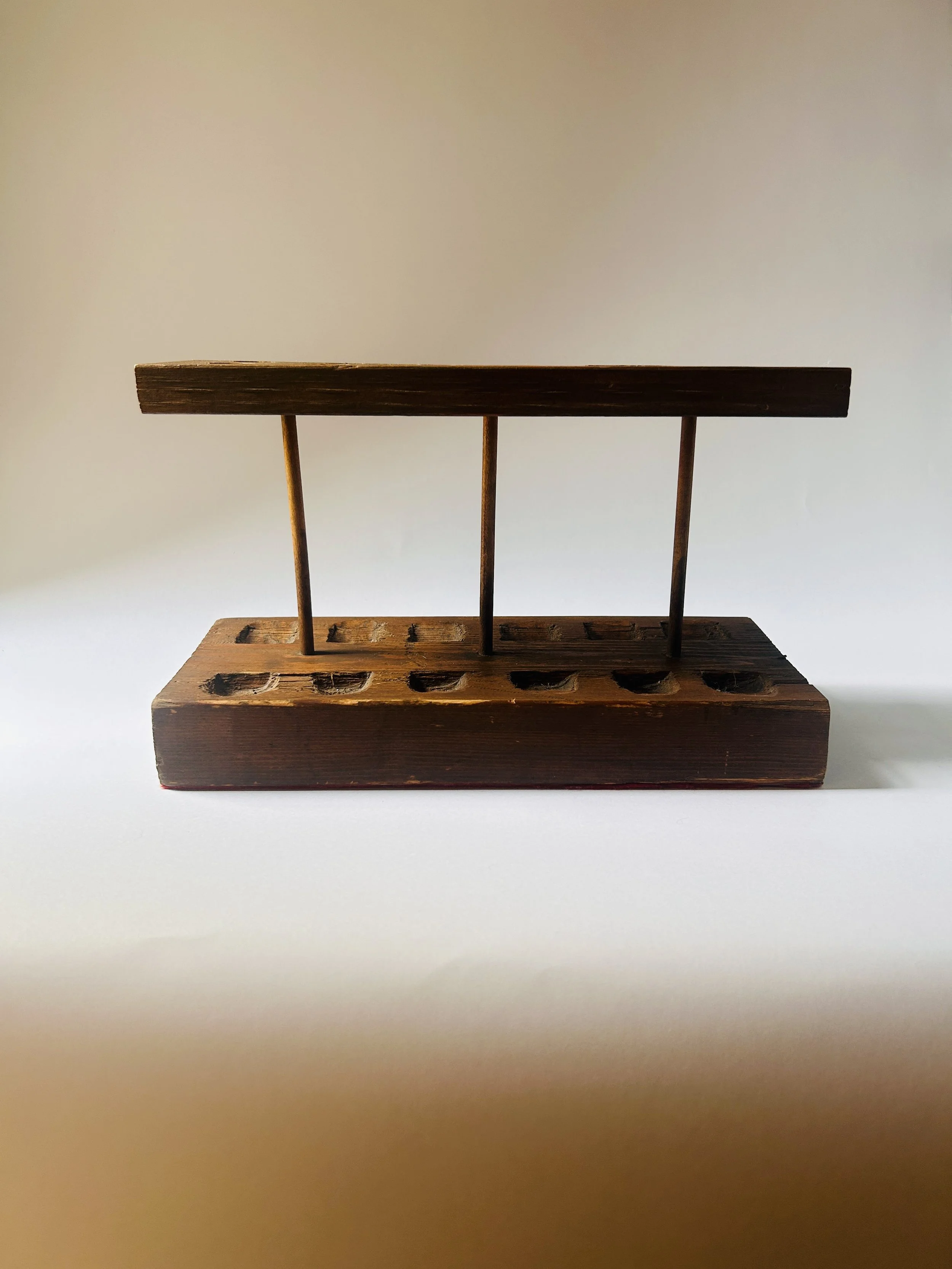Vintage wooden paint brush holder with assorted artist brushes, rustic studio organizer on neutral background