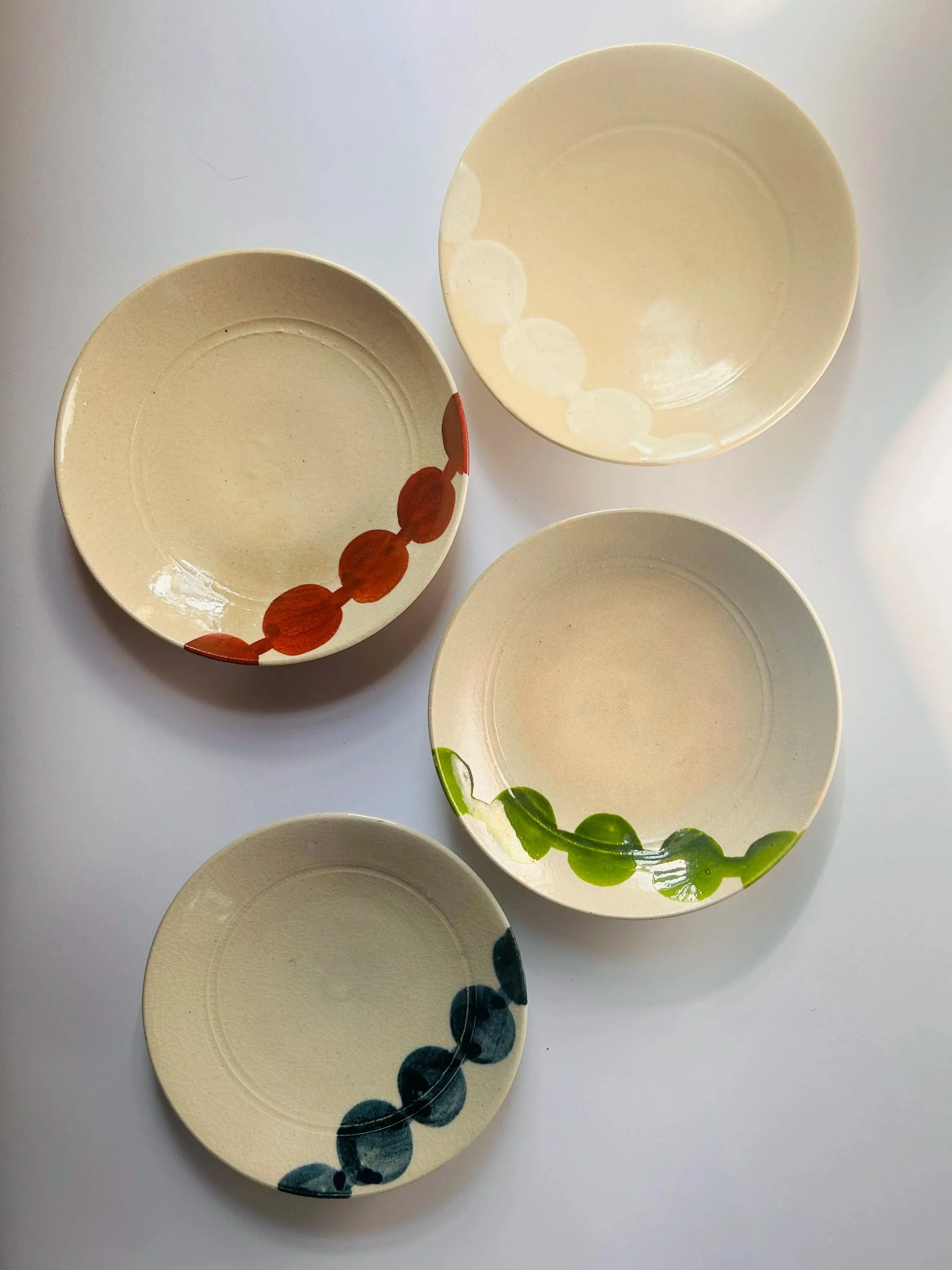 Set of vintage Japanese Miyako Odori ceramic plates with hand painted circular patterns in earthy tones