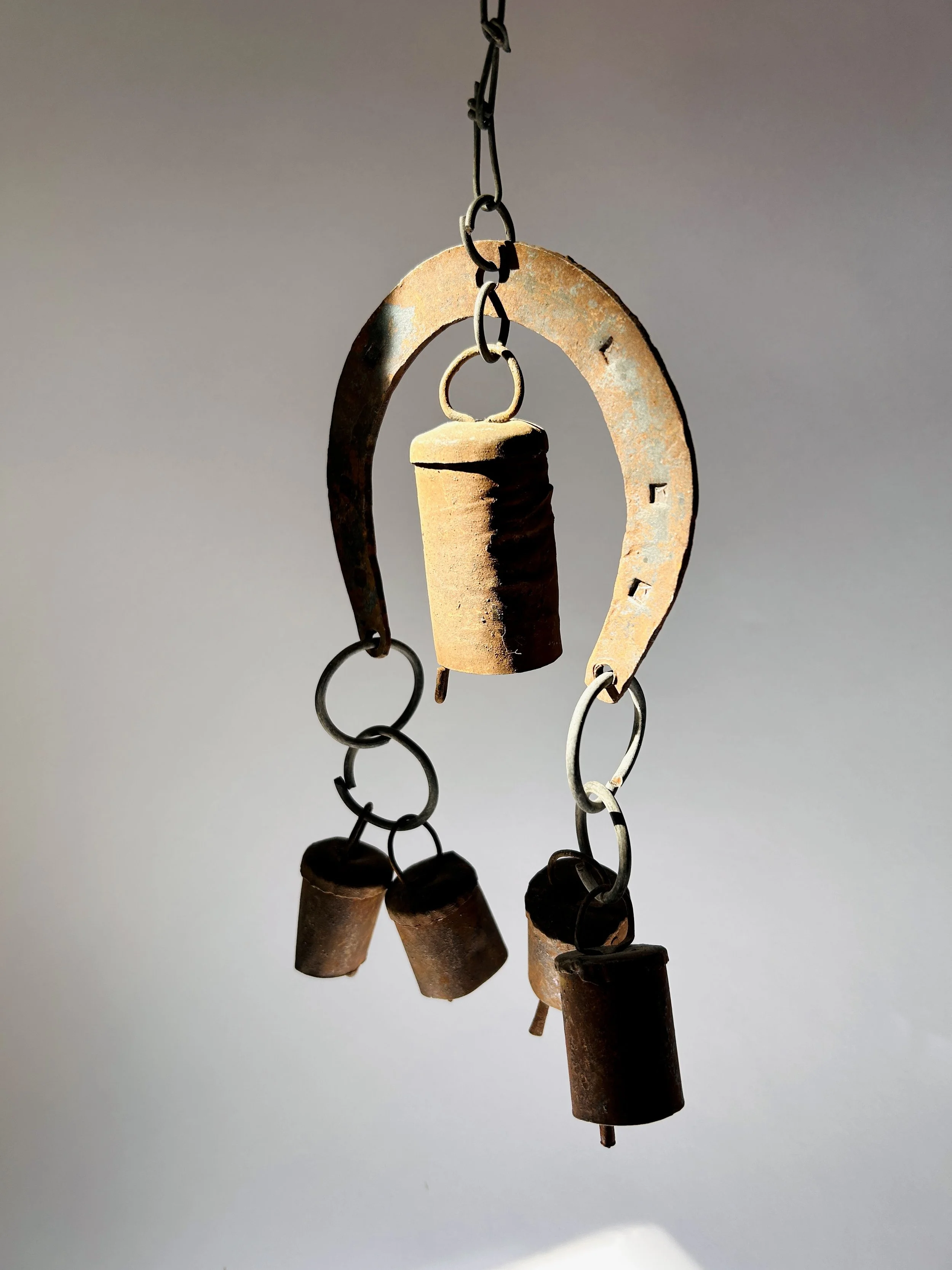 rustic metal wind chime with horseshoe frame and hanging bells