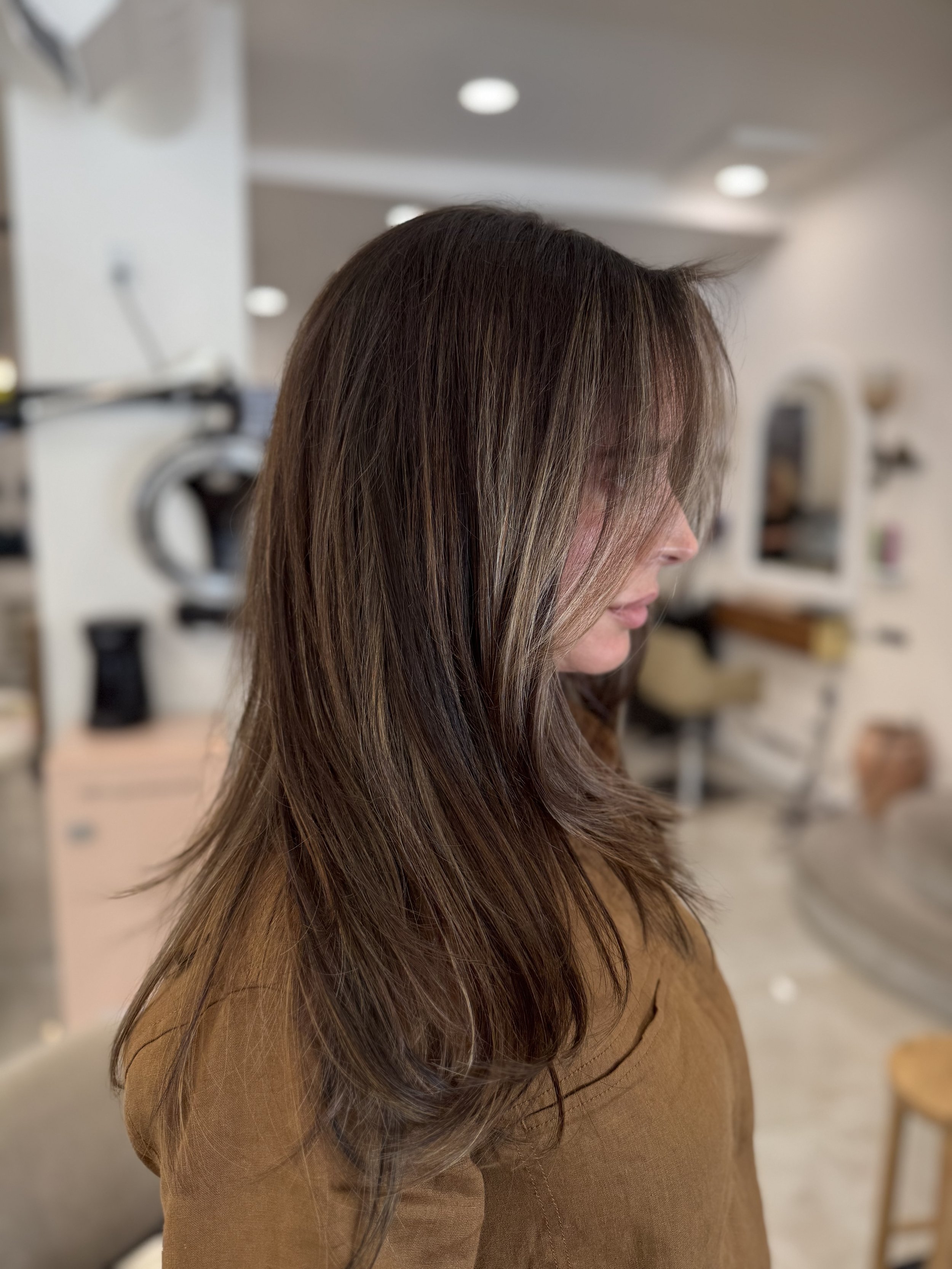 Rich brunette hair color with seamless hair extensions at GROW Hair Lounge in Atlanta.