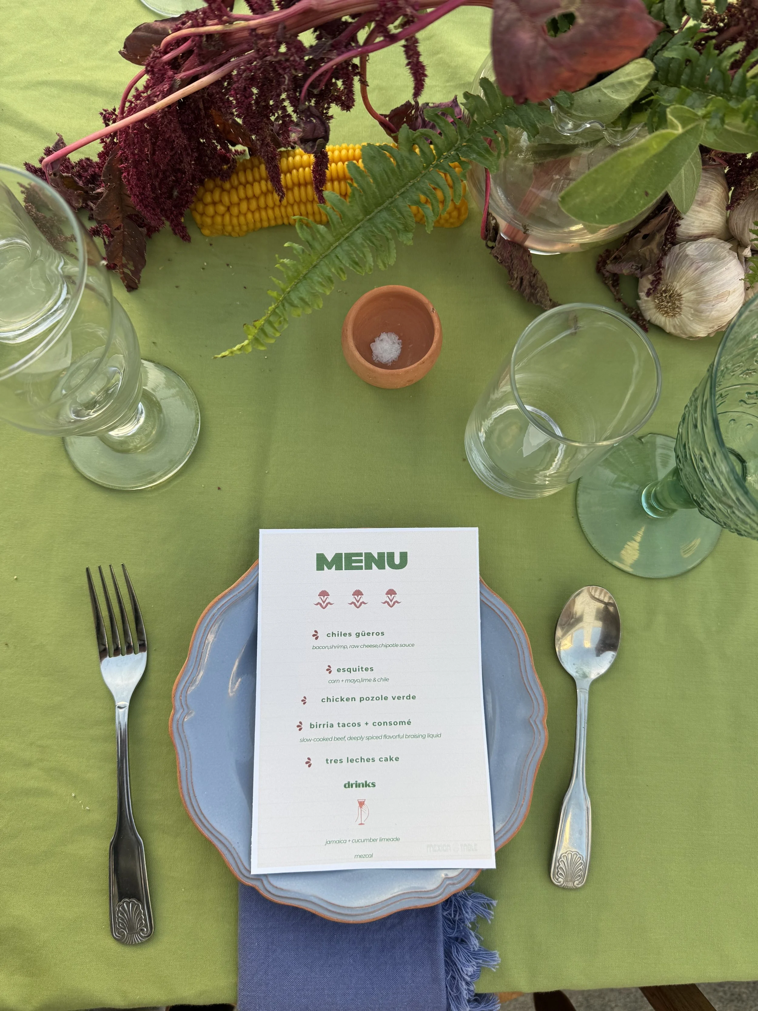Table setting on a green tablecloth.