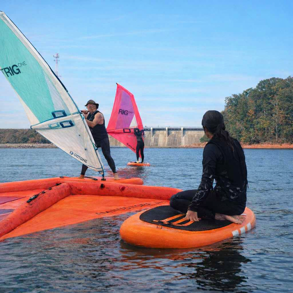 parents and a 16 yo girl on stand-up paddleboards with inflatable sails Wind-suping, on a calm body of water, at Lake Hartwell having a wind-suping lesson and trees in the background.