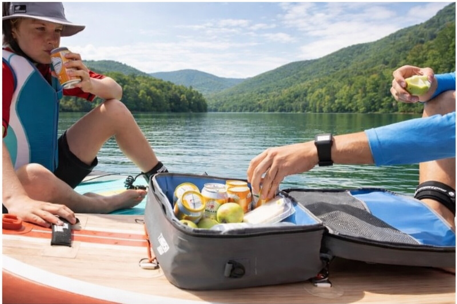 Paddleboarding picnics offered by Play Fair Paddleboarding. Mother son on paddle board on lake eating