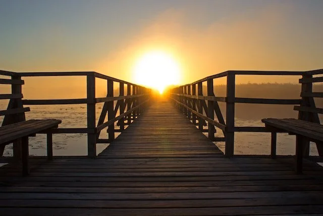 Pier over water at sunset.