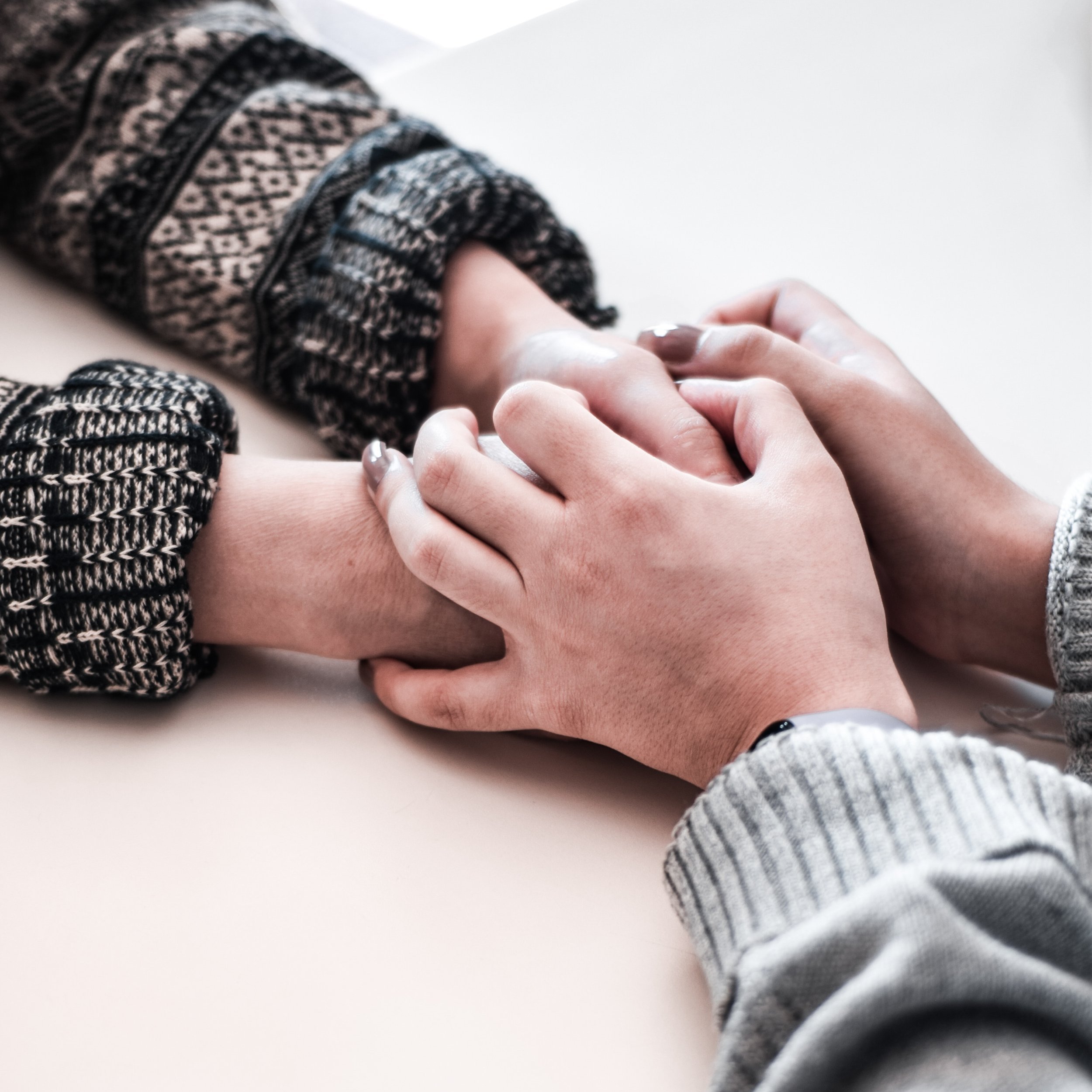 Close-up of hands clasping.