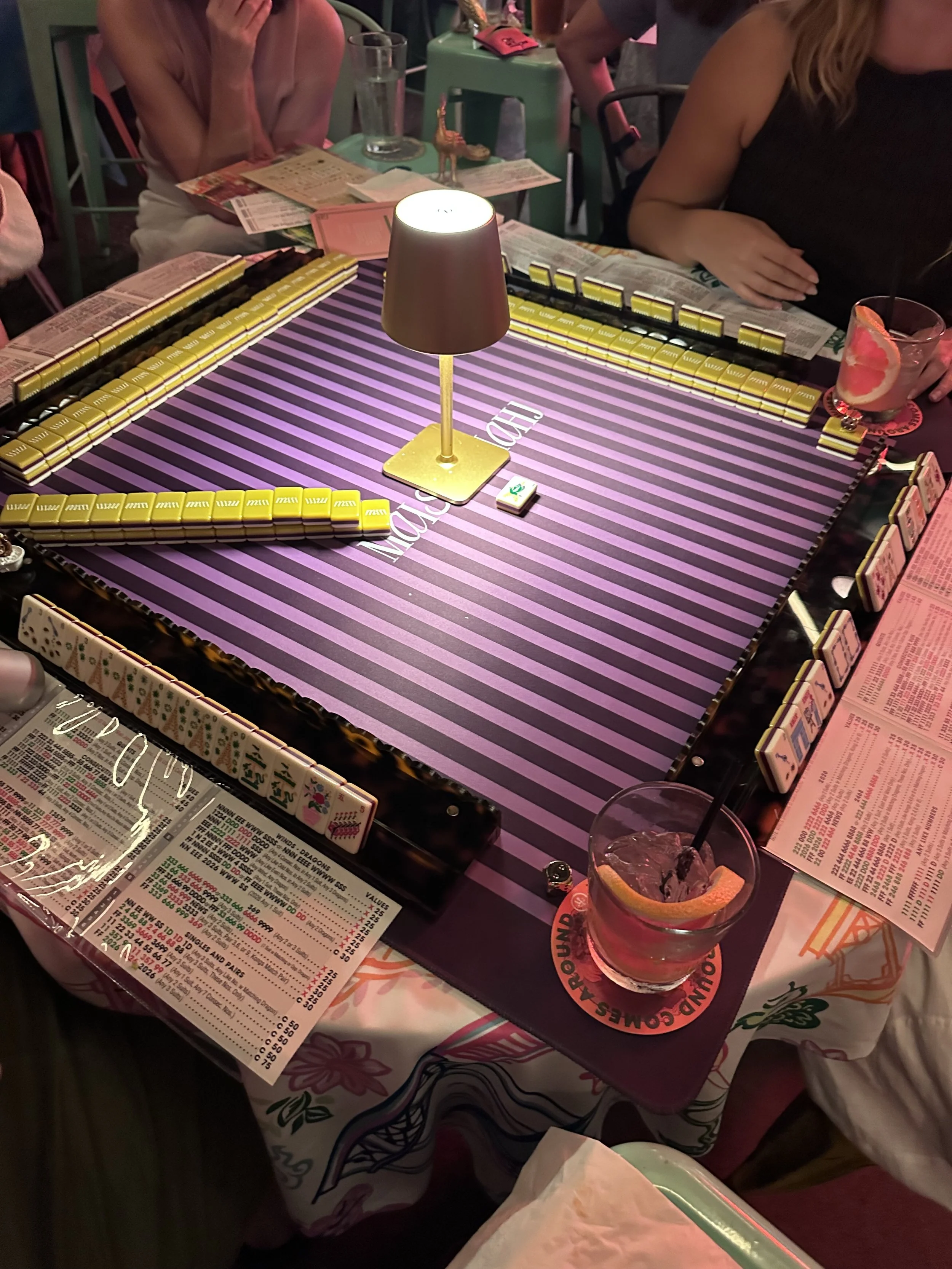 Mahjong table with a striped mat and lamp set up for open play