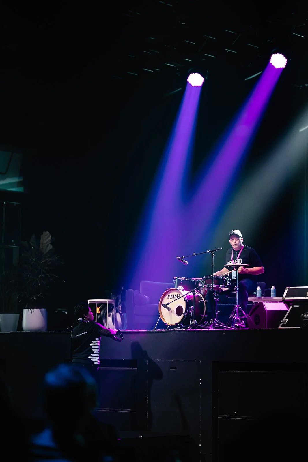 Live event production at a business conference with stage lighting and an engaged audience.
