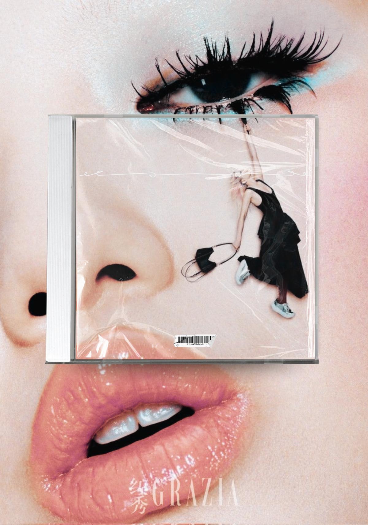 Close-up of a woman's face with a CD case placed over her nose and lips. The CD cover features a small woman in black clothing holding headphones, set against a large, detailed eye and nose of the face background, with the word 'GRAZIA' at the bottom.