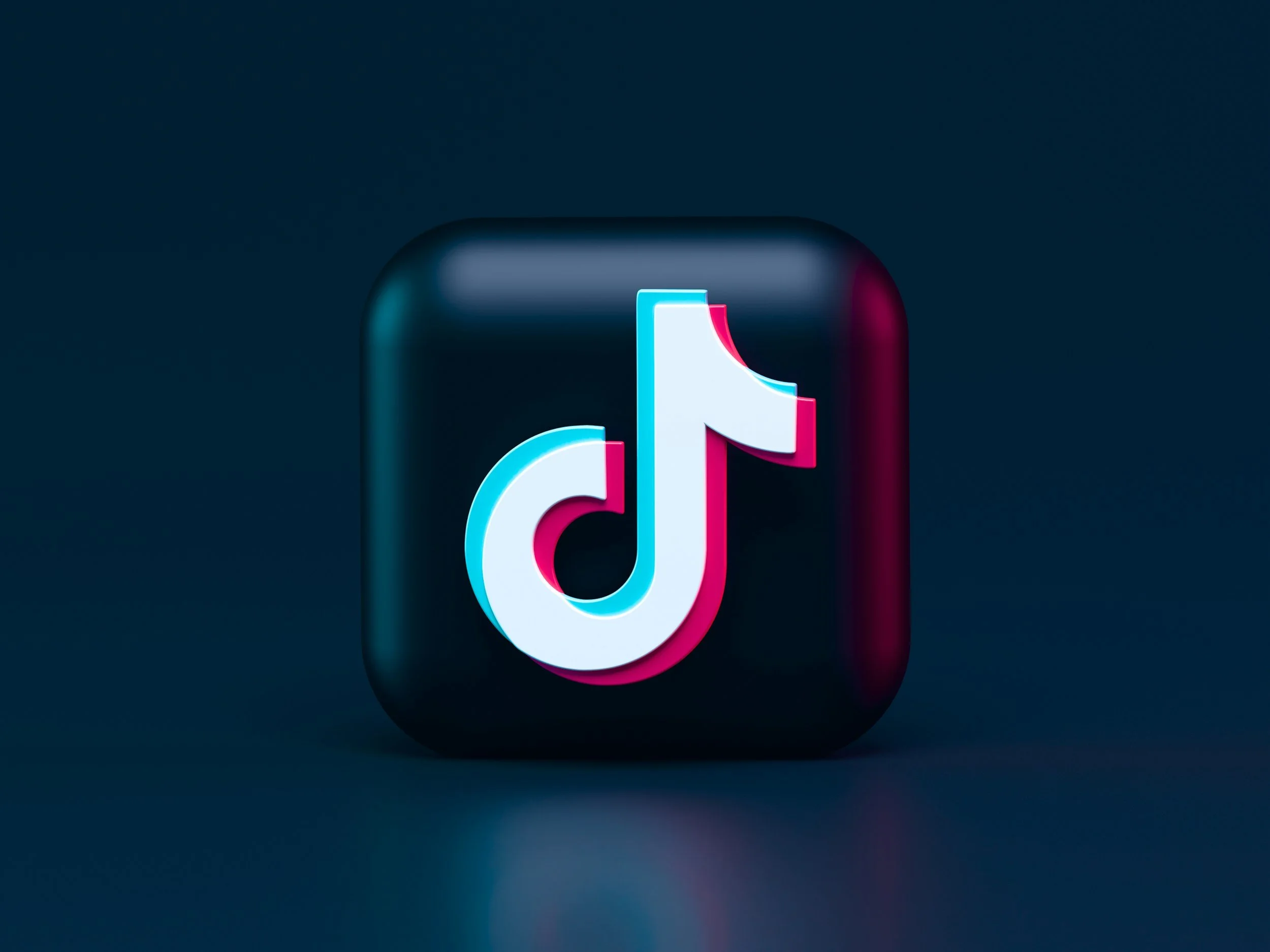 TikTok logo with glowing neon effects on a dark background.