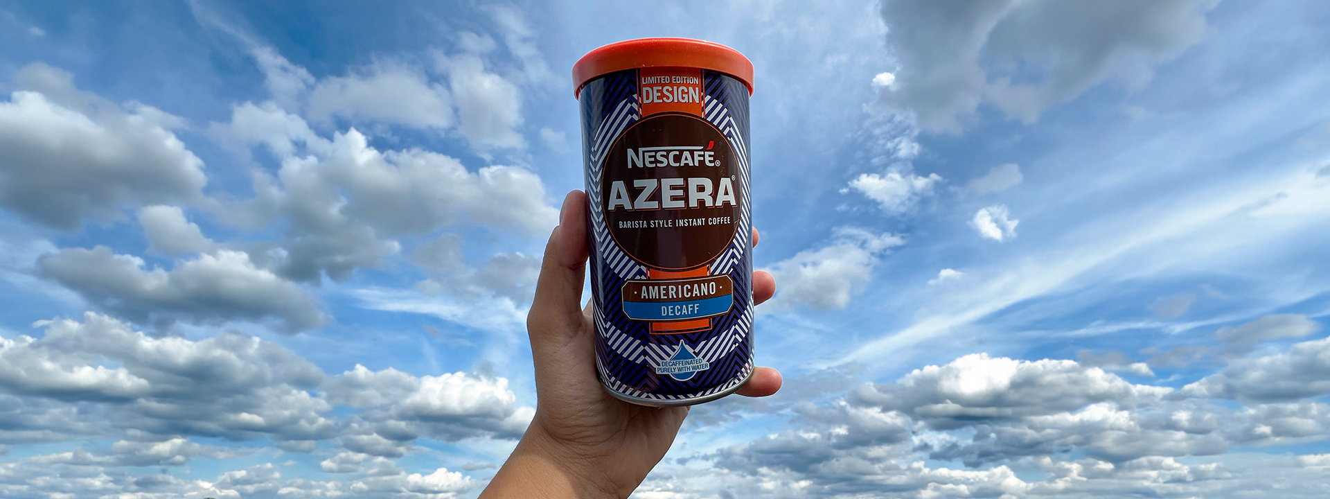 Hand holding a can of Nescafé Azera Limited Edition design