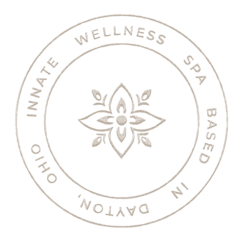 Ivory submark with a floral design in the center, surrounded by the words "Ohio INNATE WELLNESS SPA BASED in Ohio."