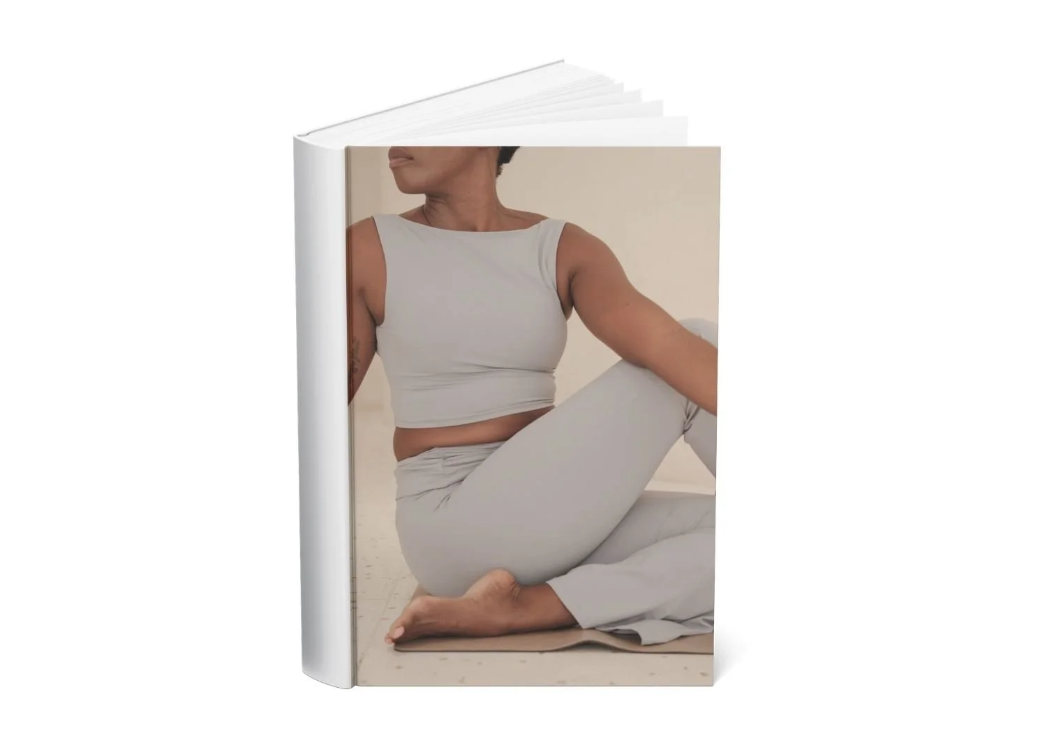 Open book displaying a woman practicing yoga indoors, sitting cross-legged on a mat.