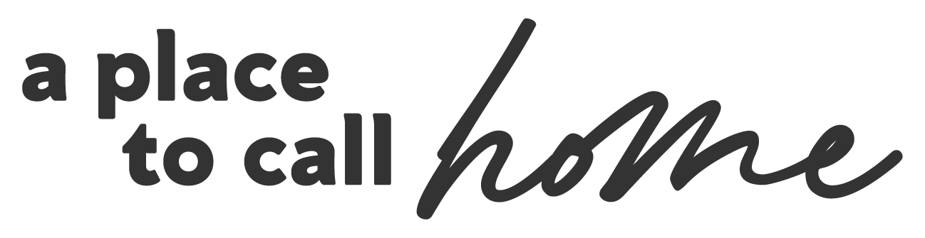 Stylized text that reads "a place to call home" in black, with a mixture of bold and script fonts on a transparent background.