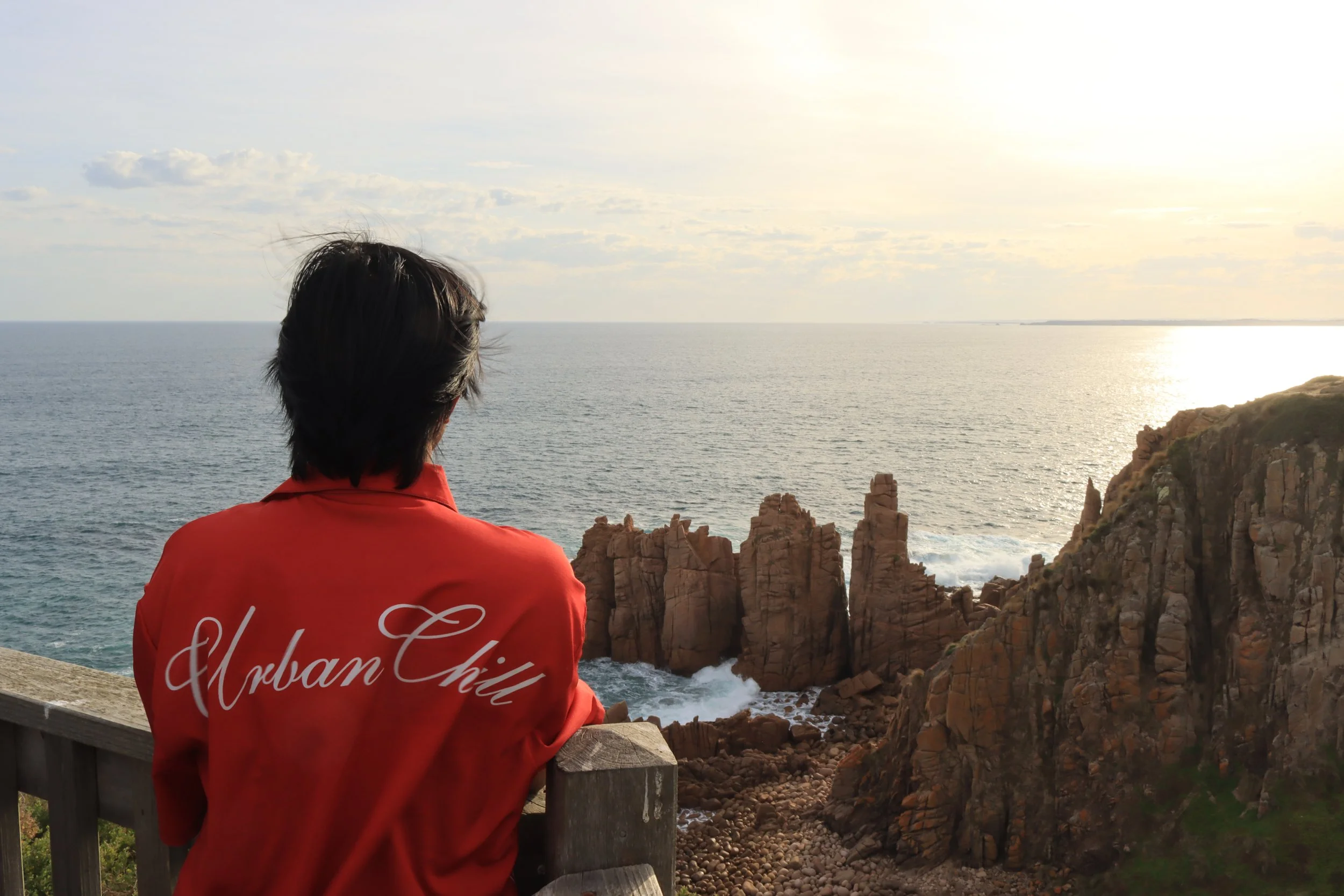 Our club member looking at rocky cliffs and the ocean during sunset during our Phillip Island Daytrip