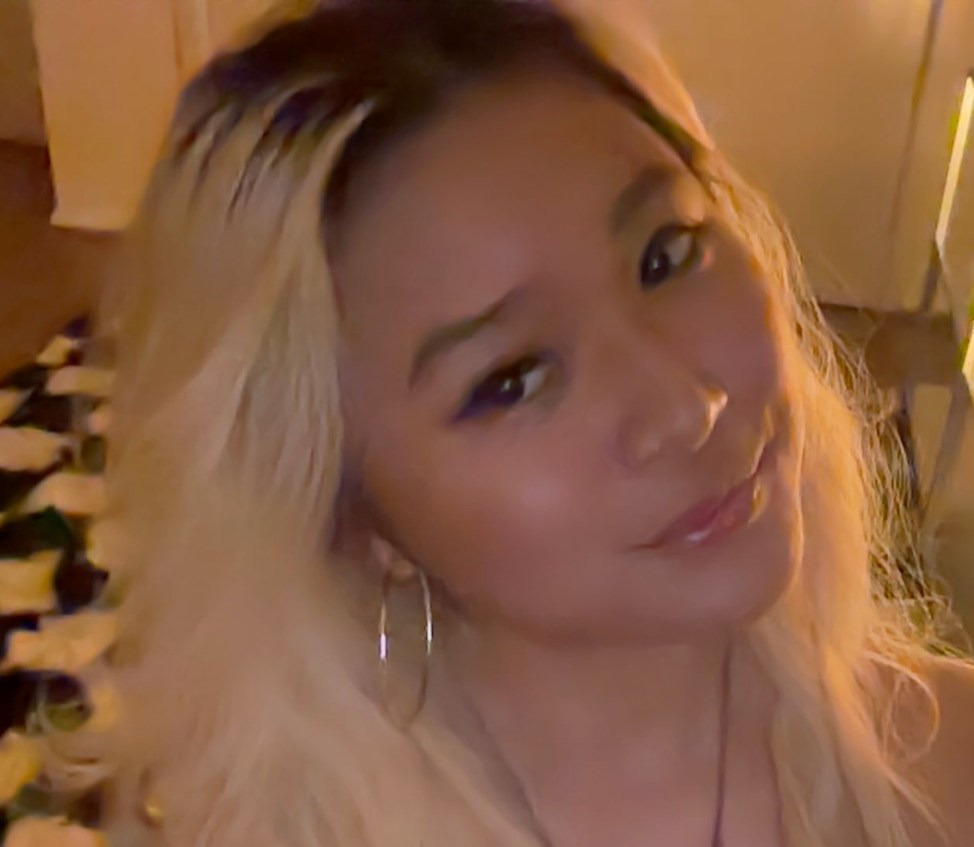 A woman (Content Creation Officer) with long blonde hair, hoop earrings, and a slight smile, looking at the camera