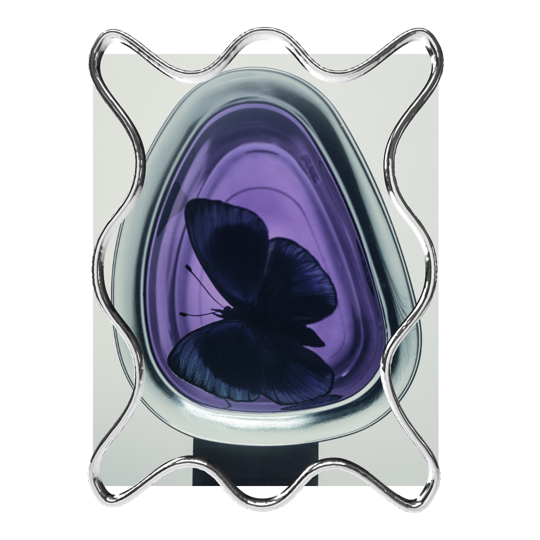 A modern decorative display with a black butterfly inside a purple and silver glass sculpture, framed by a wavy metal border.