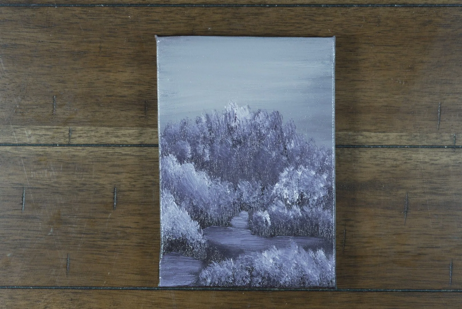 5x7 lavender forest path oil painting on cradled canvas laid on a dark wood floor