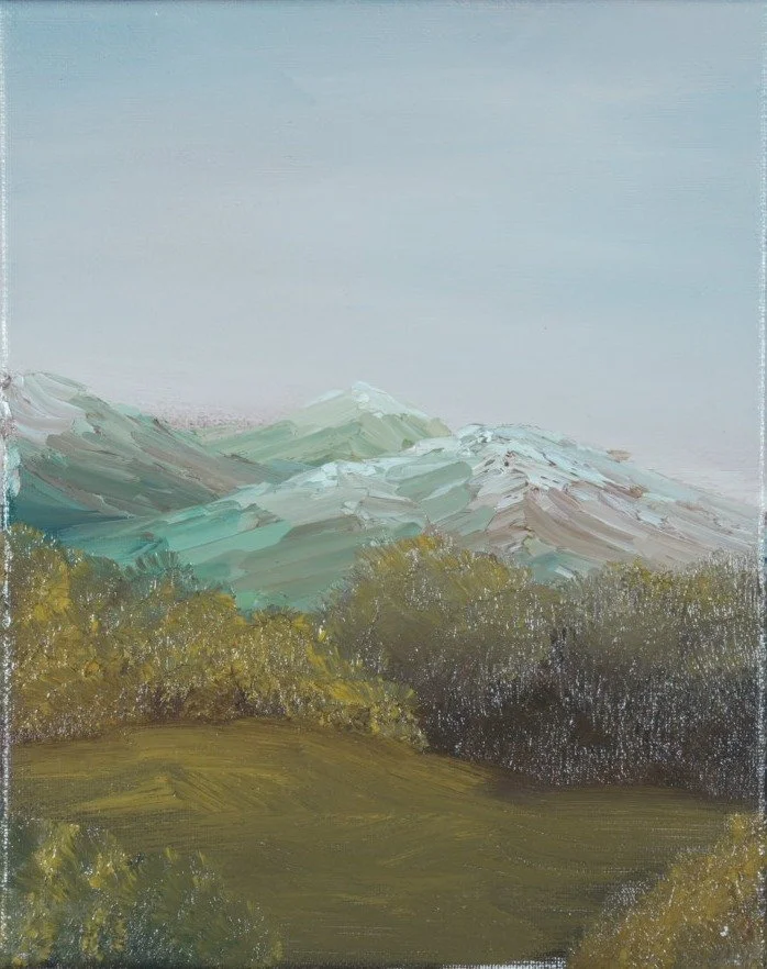 Snow-dusted teal peaks rising above a golden meadow, center panel of a mountain triptych